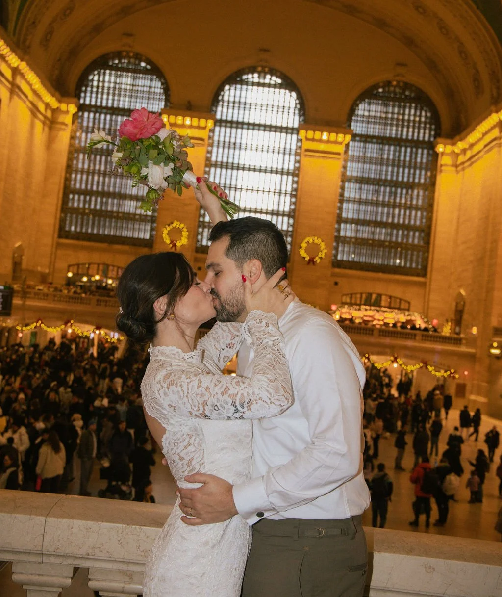 Newly married couple kisses in Grand Central Station after they eloped with documentary style photography with Cakewalk.