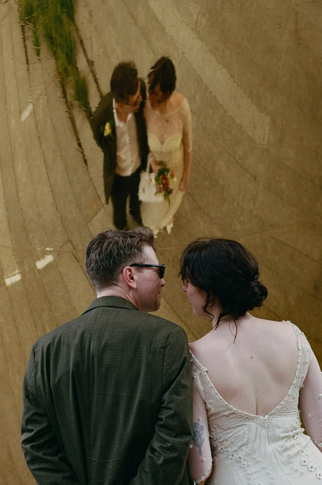 Bride and groom looking at each other on the High Line, with their reflection mirrored above them. 