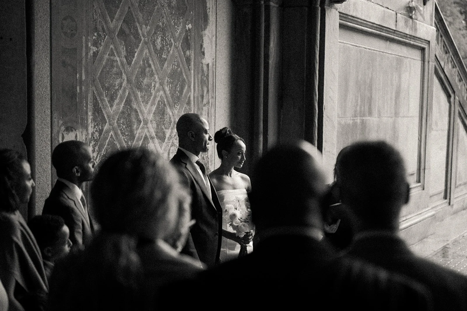Bride and groom being married by Cakewalk officiant at Bethesda Terrace, seen through their family audience, during their micro wedding ceremony.