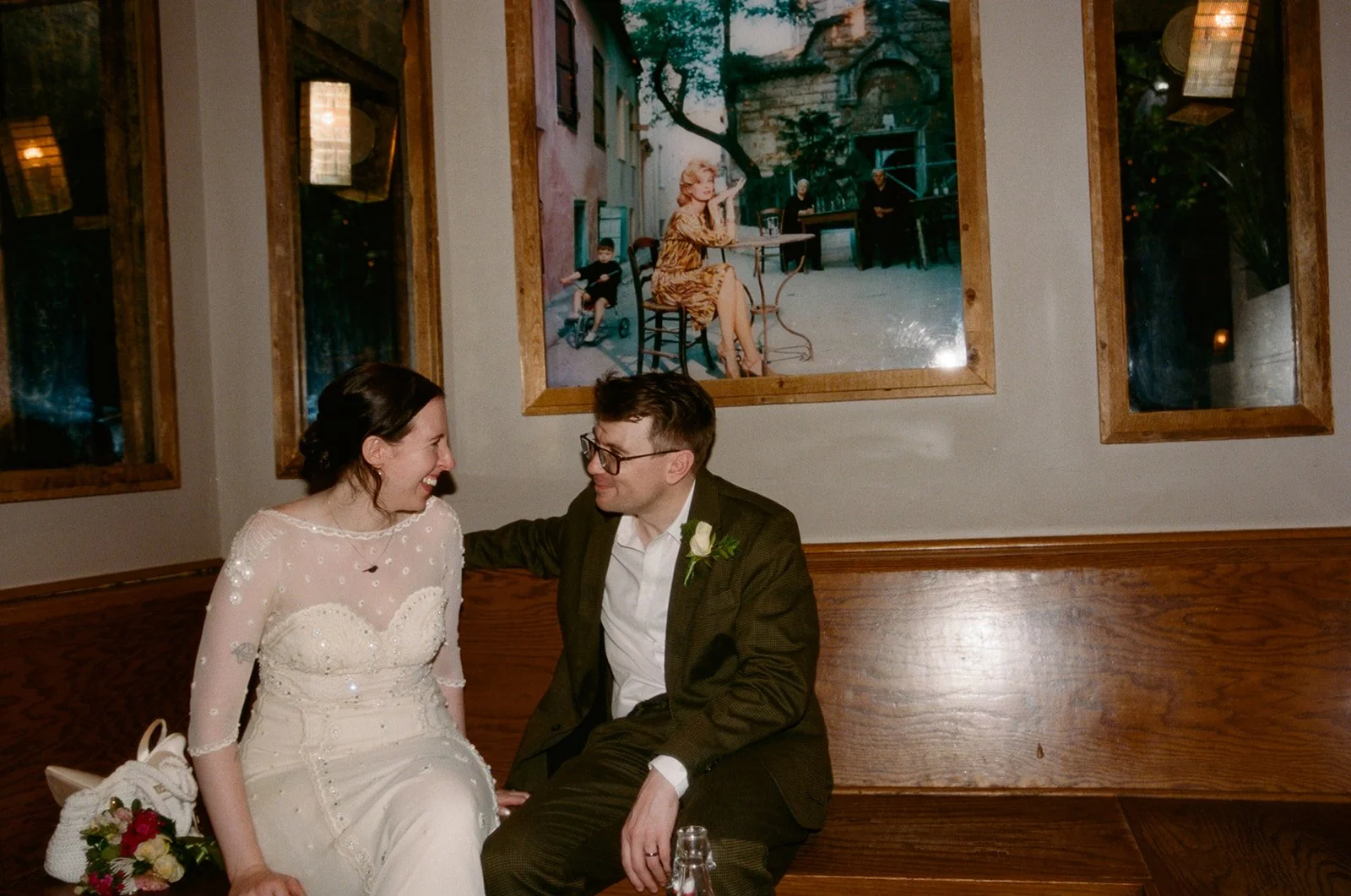 Bride and groom seated on a bar bench near Manhattan's High Line after their Cakewalk elopement.