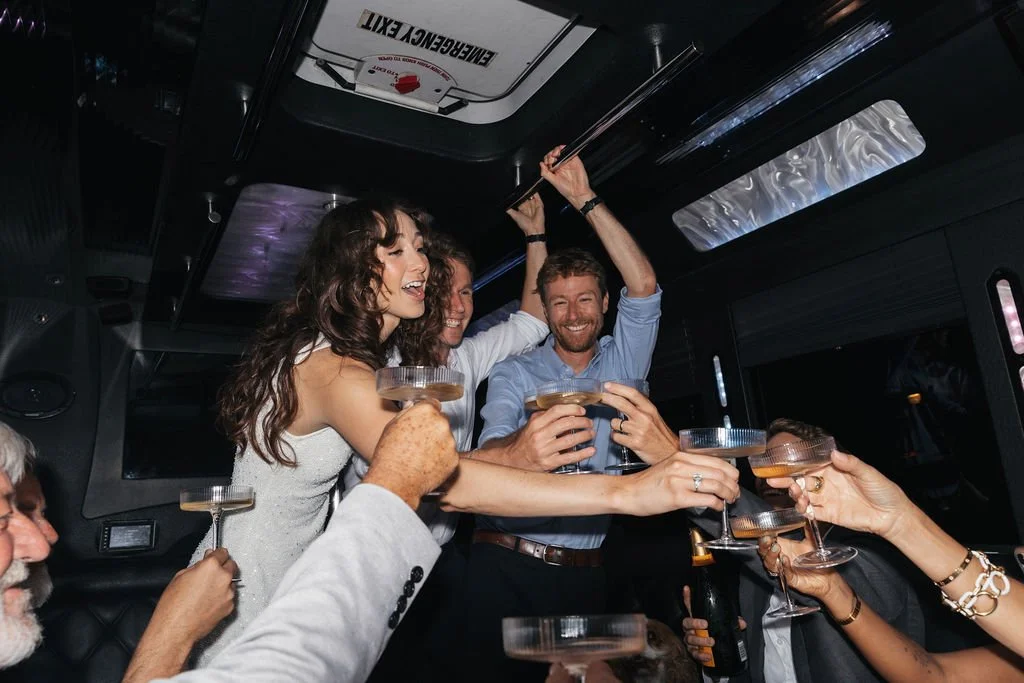 Couple celebrating their Cakewalk elopement on a party bus on the way to Hollywood, sharing drinks.