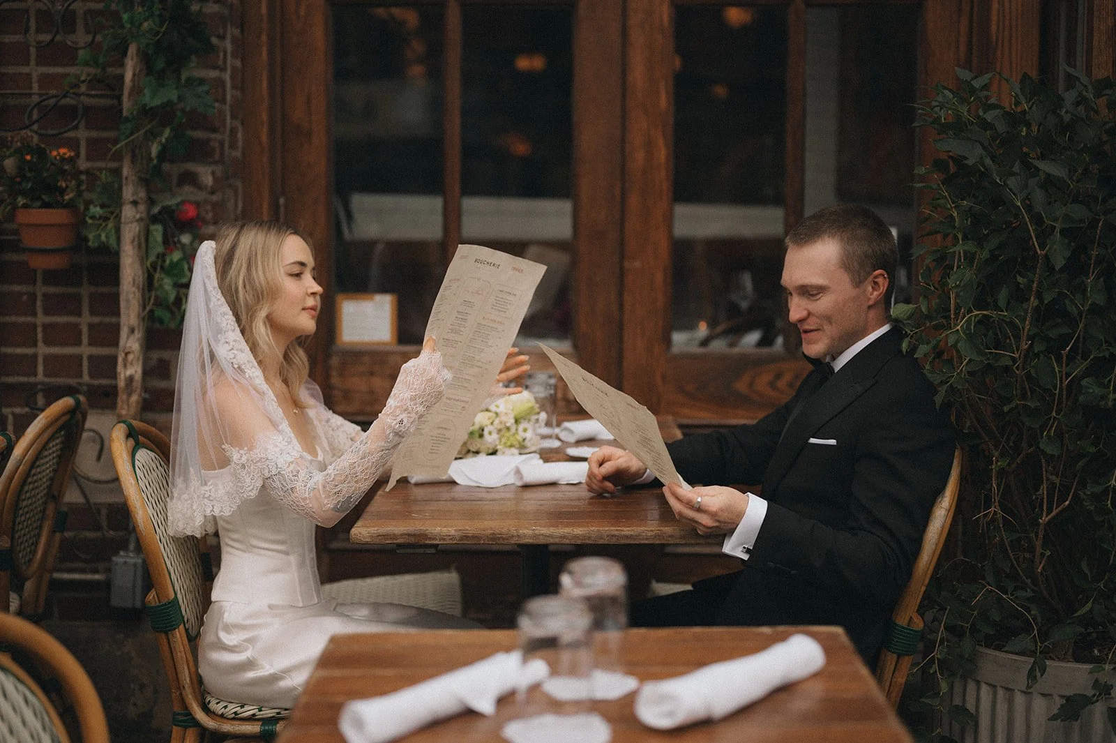 Couple reading menus at dinner in the West Village after their Cakewalk elopement.