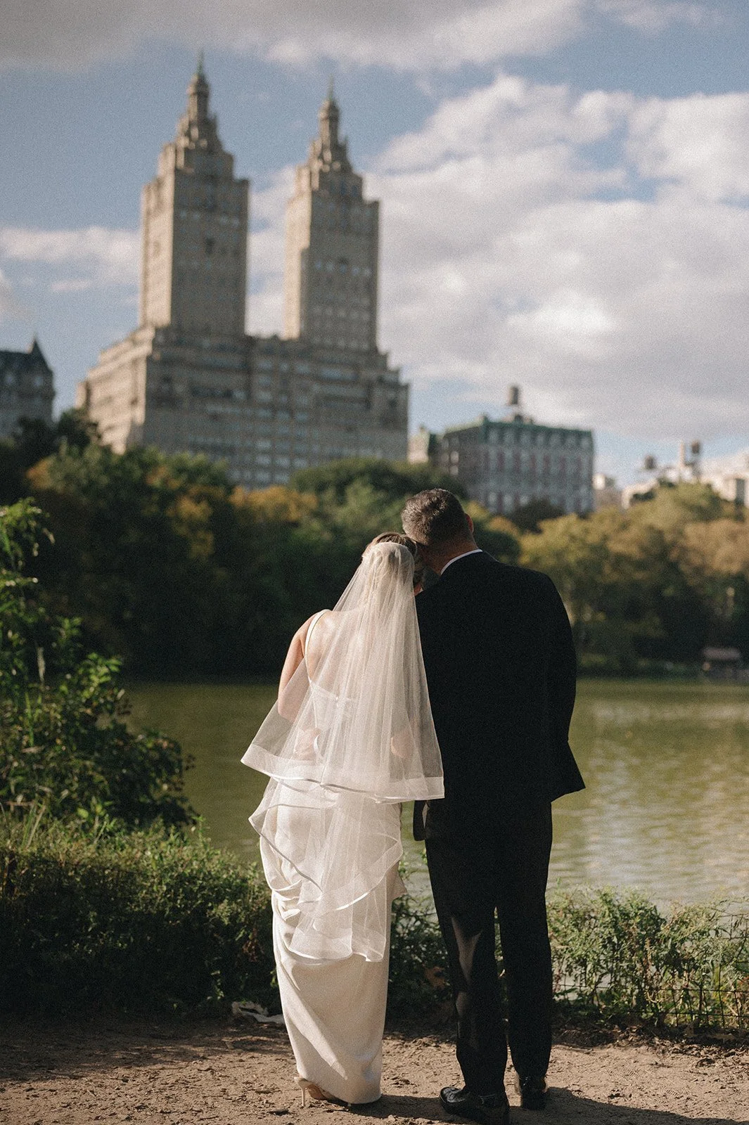 Bride and groom admiring the skyline from the water in Central Park.