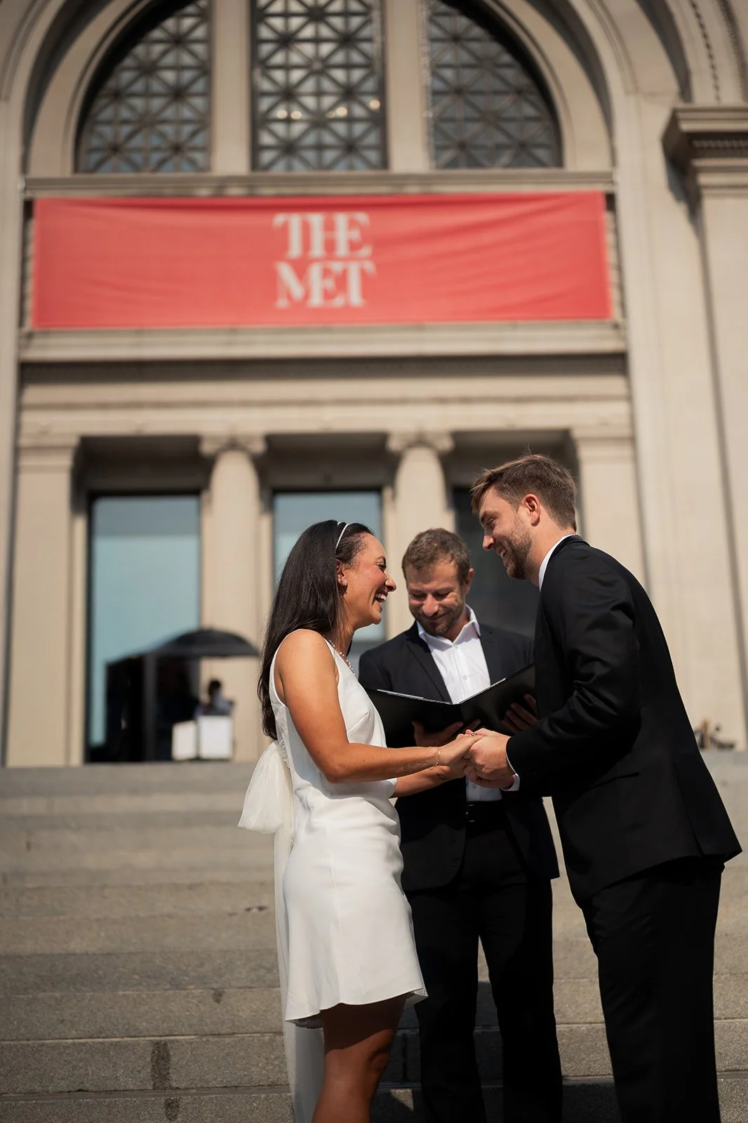 Couple exchanging vows on the steps of The Met in New York City during an intimate elopement ceremony.