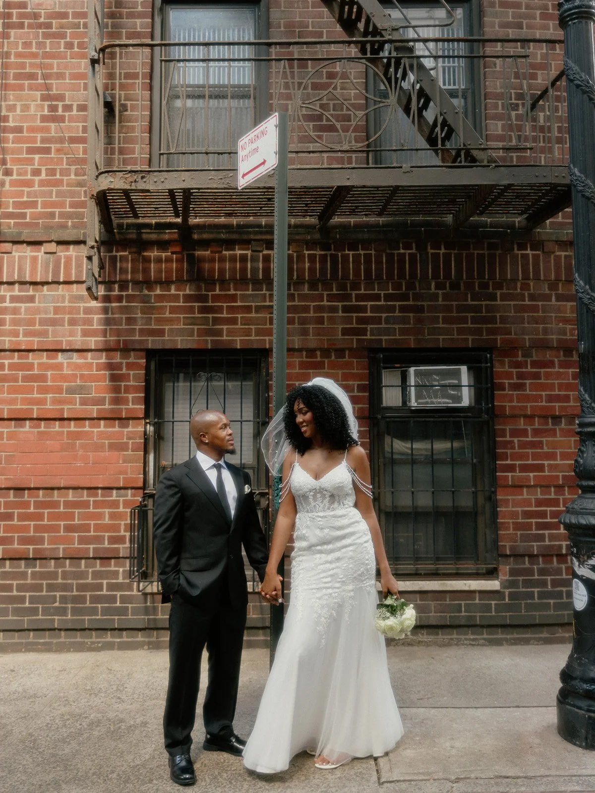 Bride and groom standing against a brick building after their Cakewalk elopement.