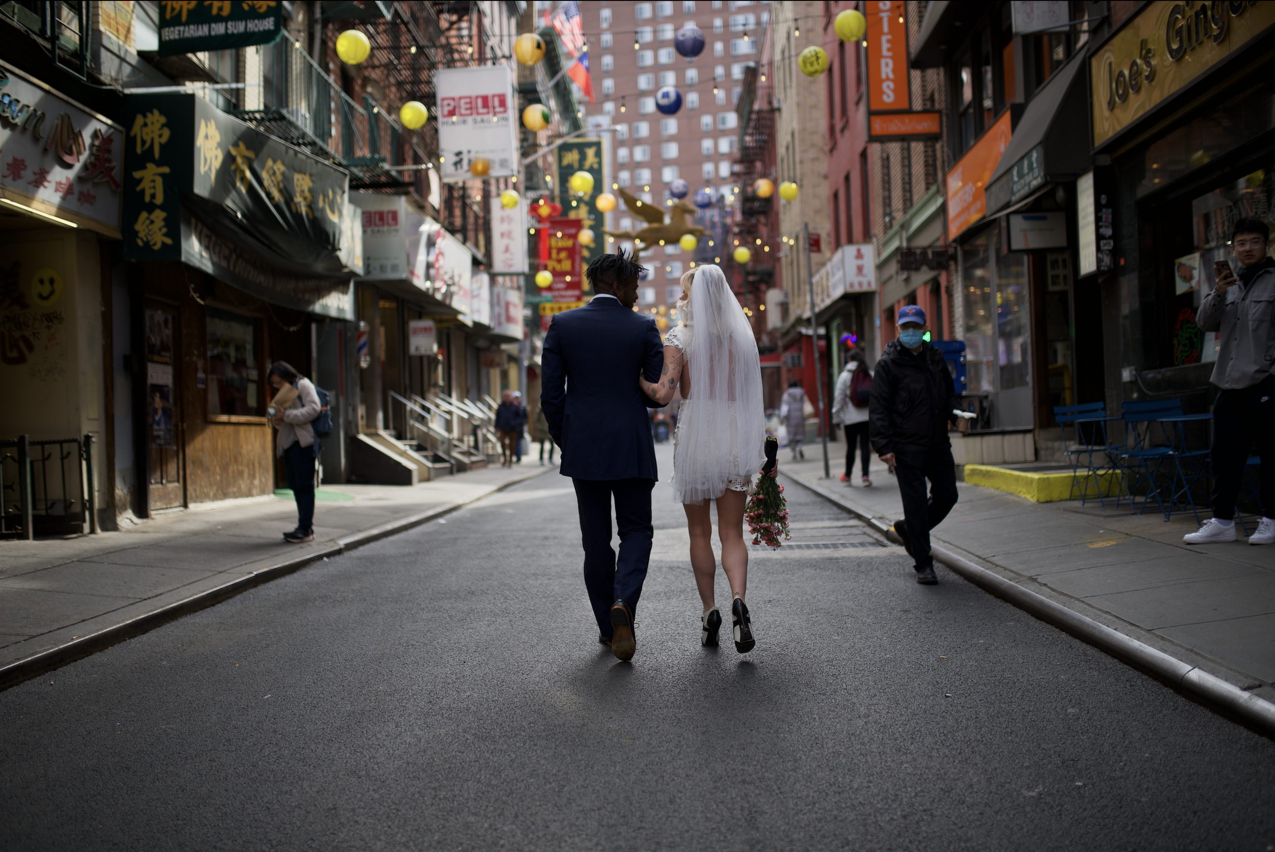 Bride and groom walking down the street arm-in-arm in Chinatown after their Cakewalk elopement.