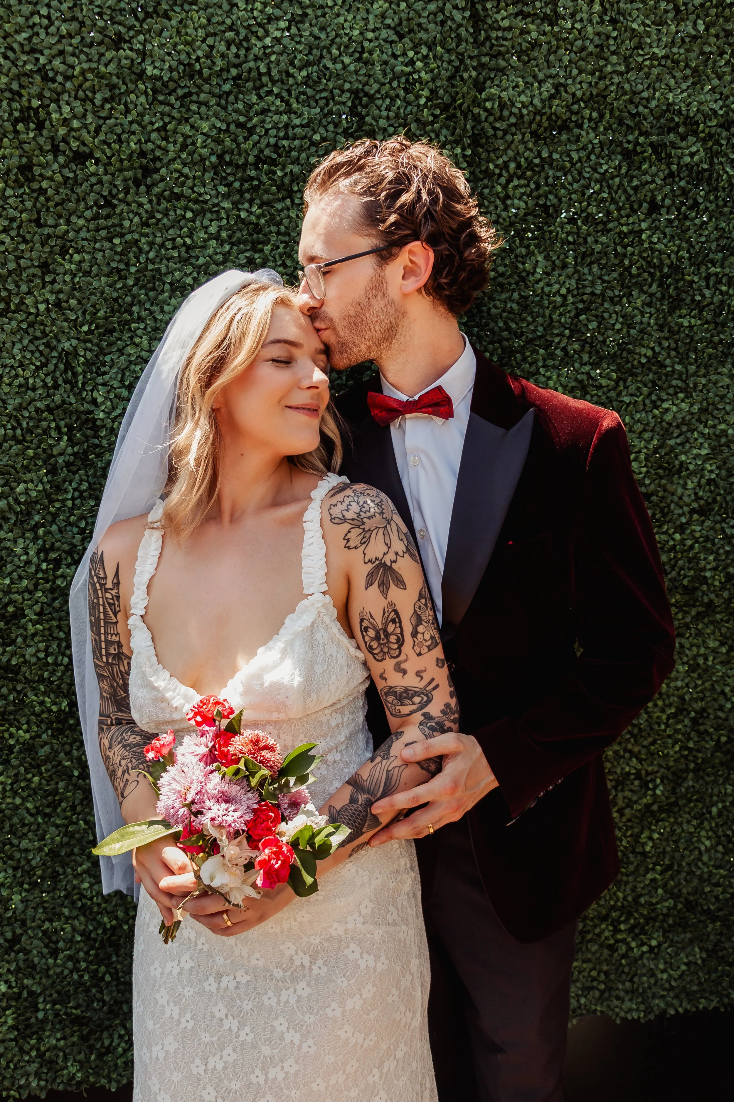 Couple posing in front of greenery at Lemon Grove at their Cakewalk elopement in Hollywood.