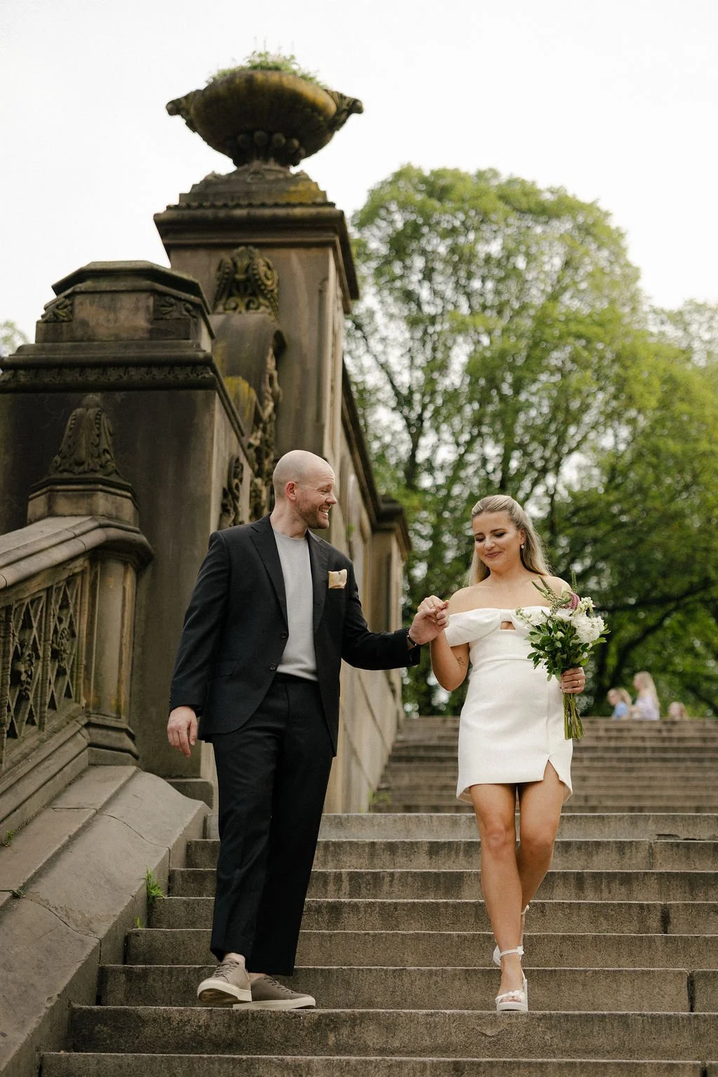 Bride and groom walking down a staircase in Central Park, on the way to their Cakewalk elopement.