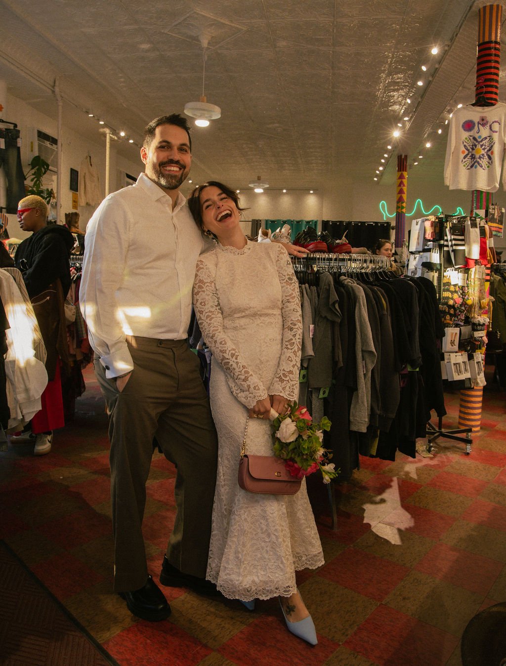 Newly married couple smiling in a thrift shop after their NYC Cakewalk elopement ceremony.