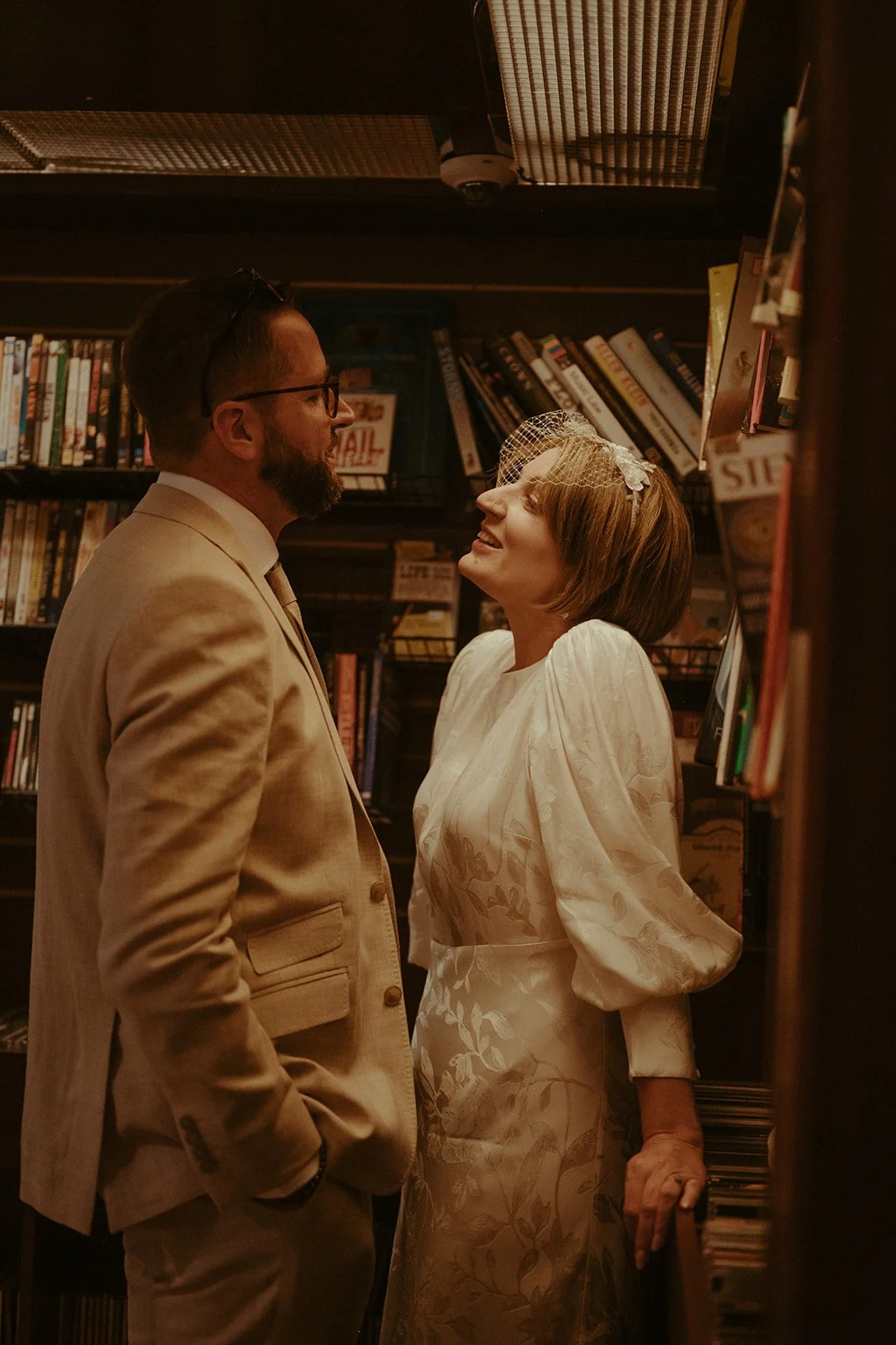 Couple sharing a quiet moment between bookshelves during a Housing Works Bookstore elopement.