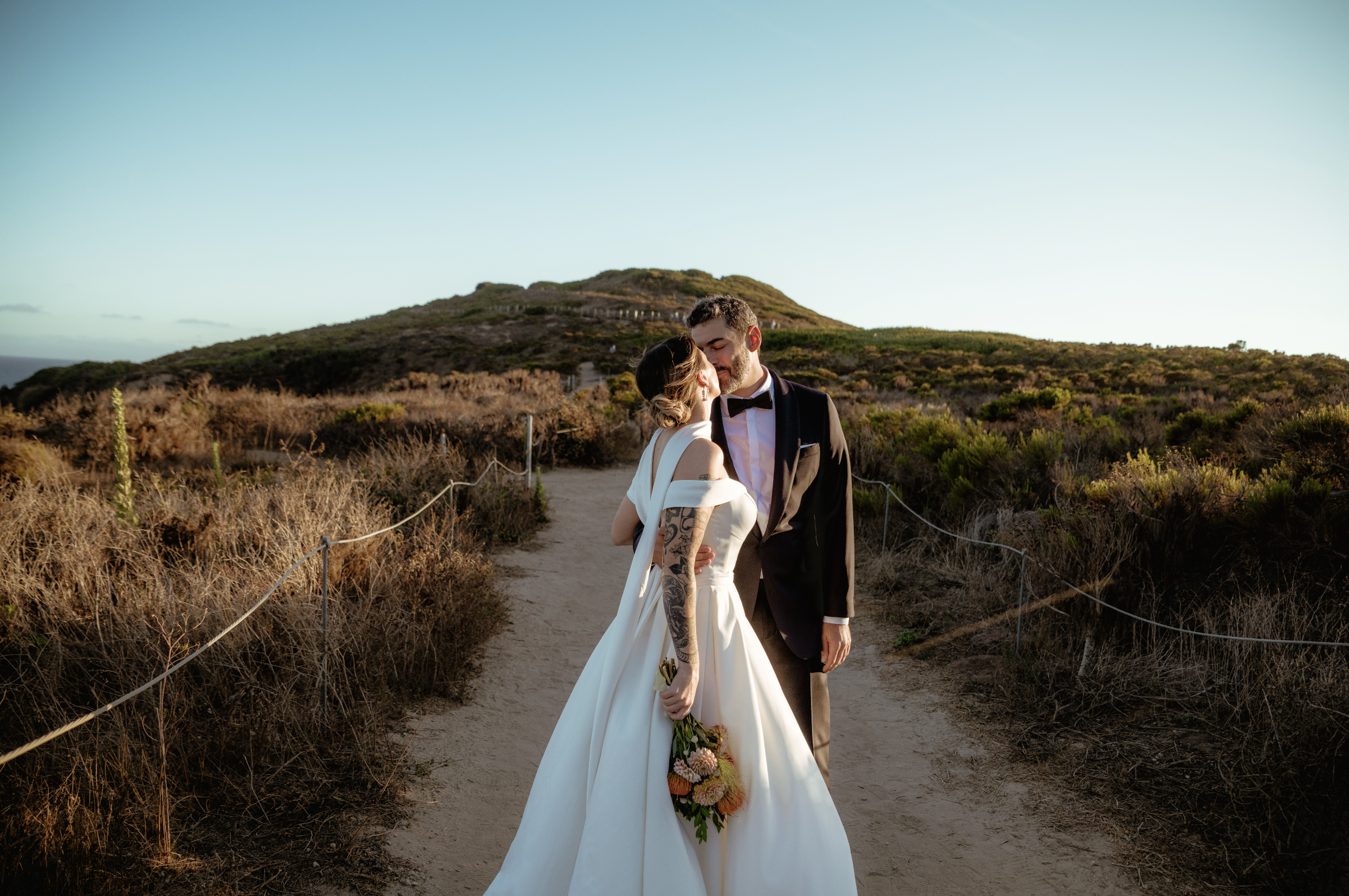 Bride and groom kissing on the trails at Point Dume after their Cakewalk micro wedding.