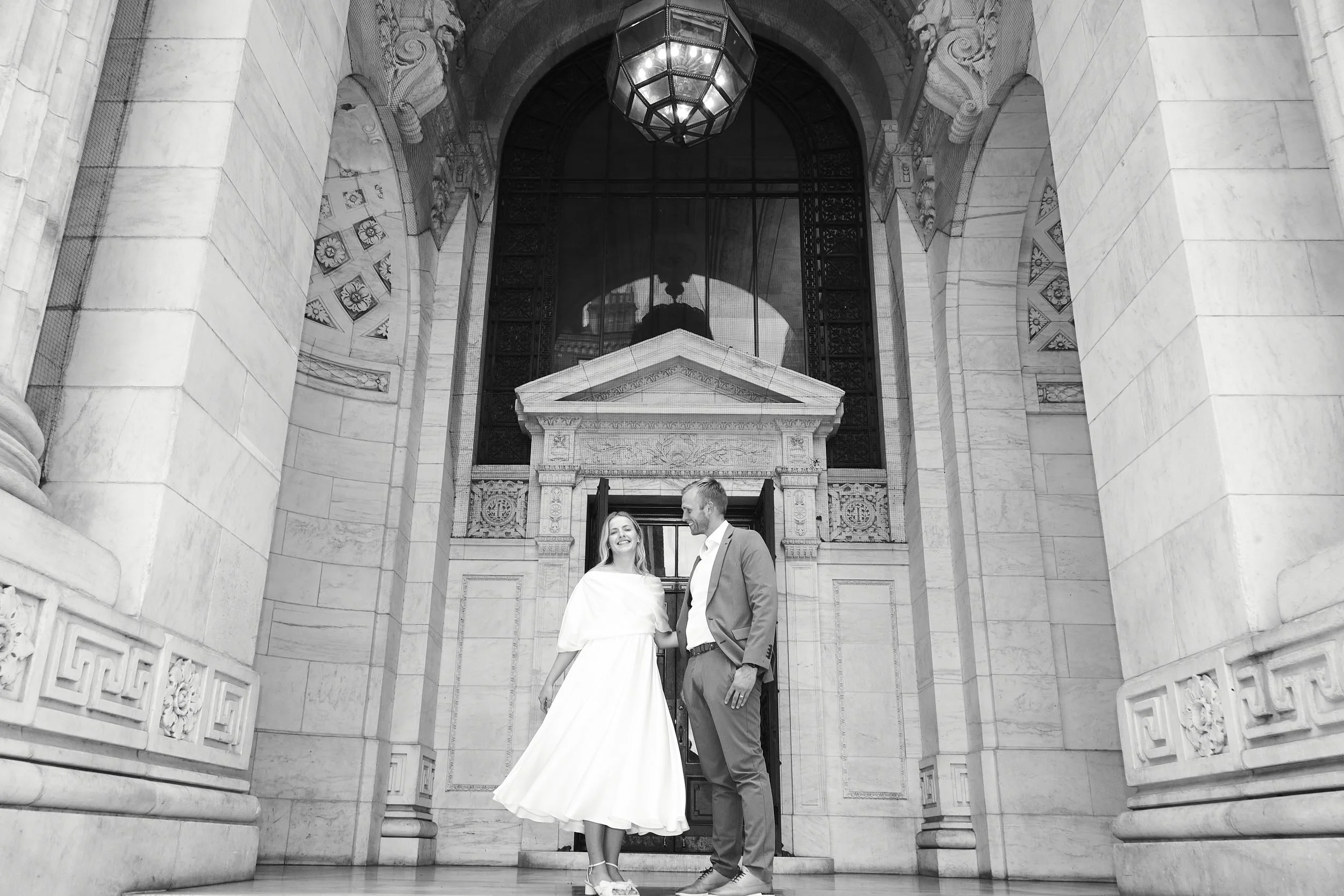 Bride and groom smiling and dancing on the stairs at Bryant Park after their Cakewalk elopement.