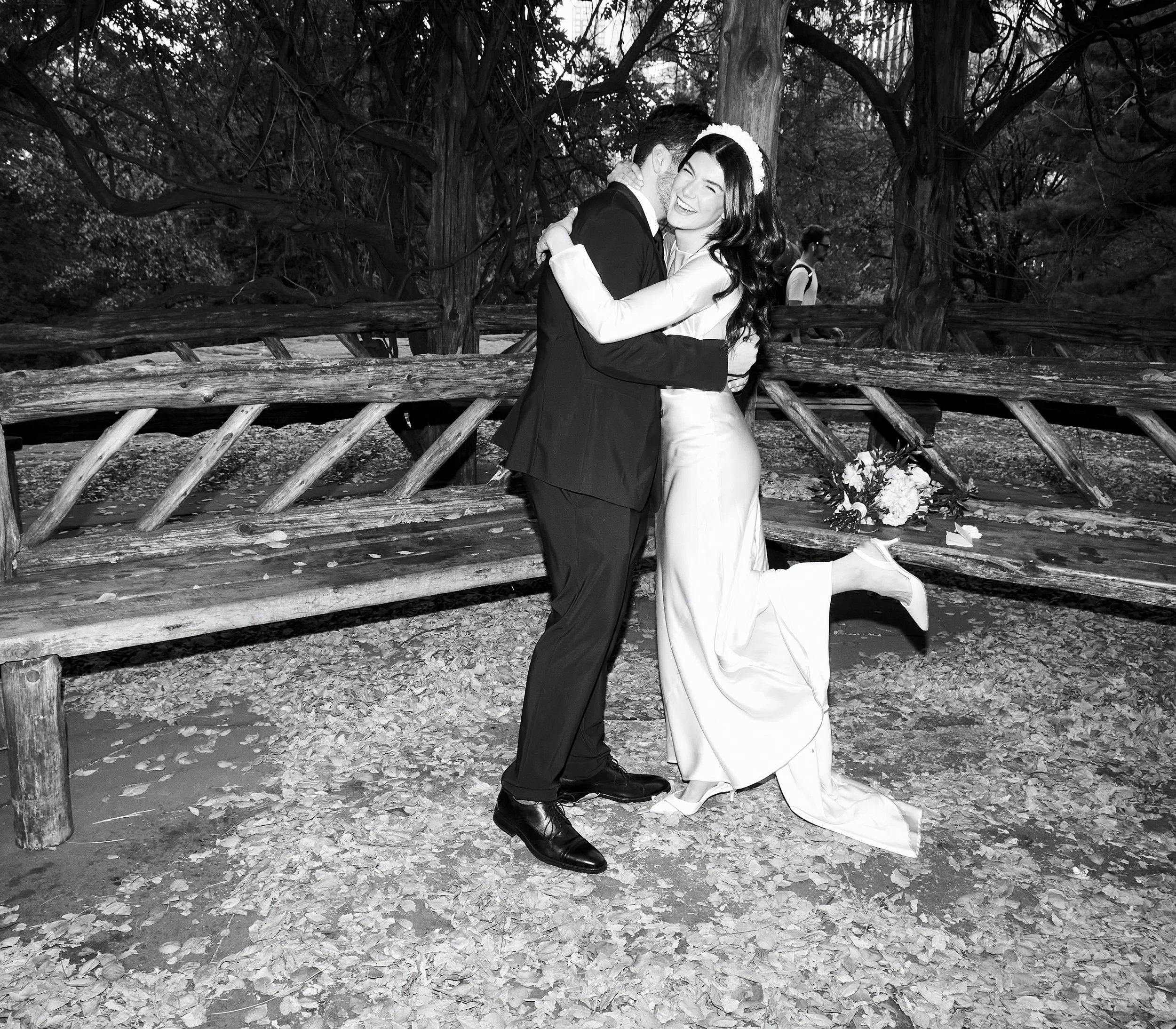 Black and white photo of Sharifa and Jafar embracing under the Cop Cot wooden gazebo in Central Park.
