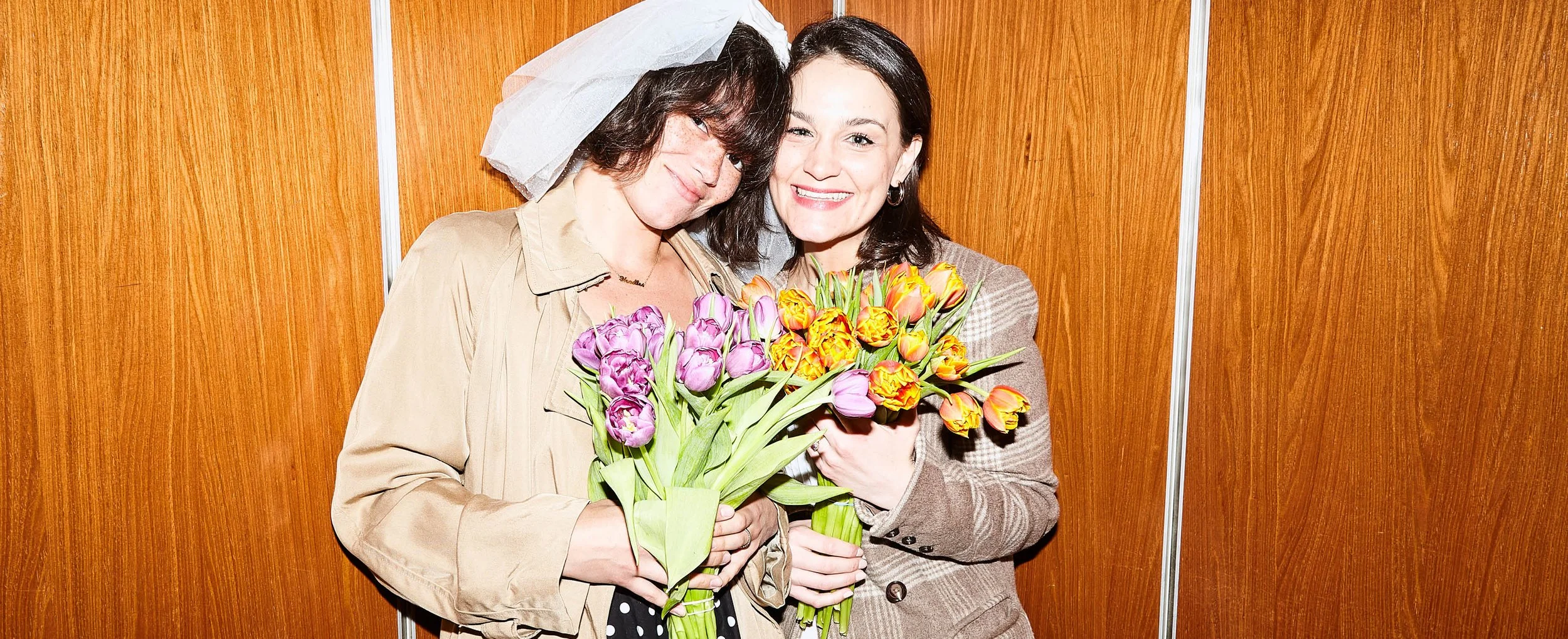 LGBT eloping couple posing for wedding photos in the elevator of their Fort Greene Park apartment before their elopement ceremony in Brooklyn, New York after they plan a small wedding.