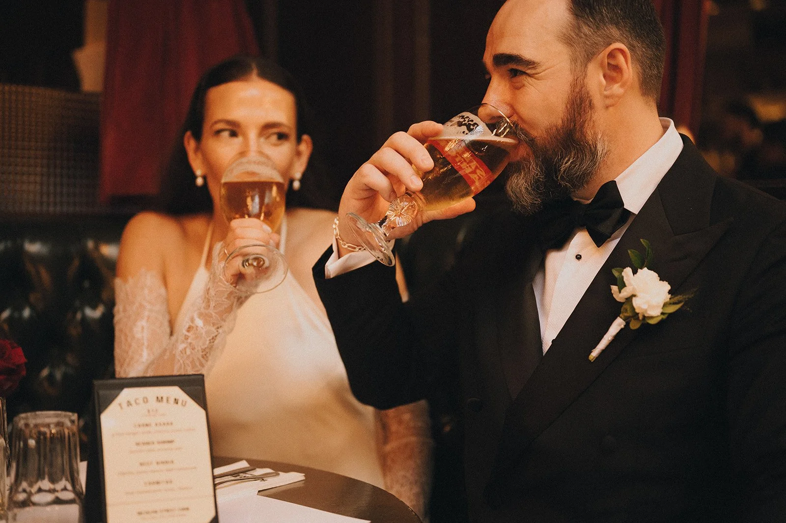 Bride and groom drinking beers at a Fifth Avenue bar after their Cakewalk elopement in New York City.