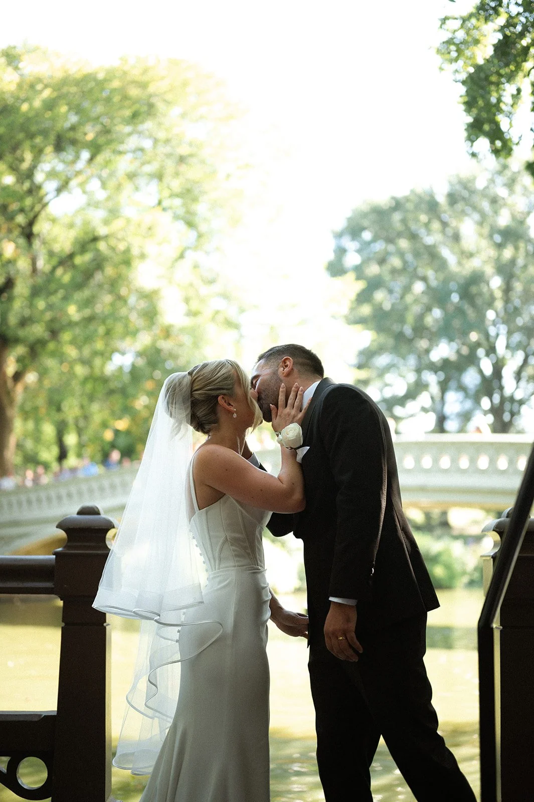 Bride and groom kissing in front of Bow Bridge in Central Park, NYC after their Cakewalk elopement.