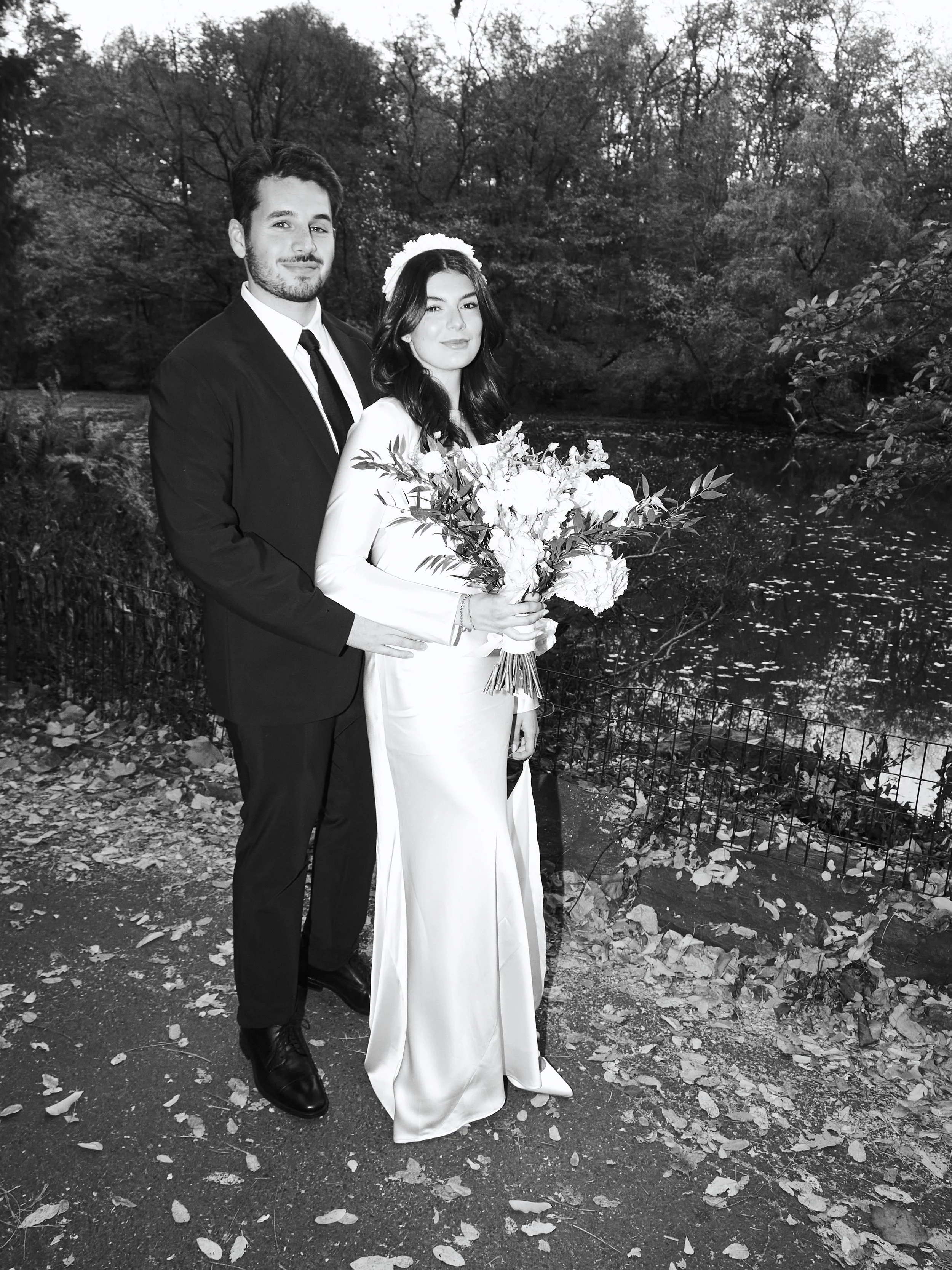 Bride and groom posing by the water at Cop Cot in Central Park after their Cakewalk micro wedding.