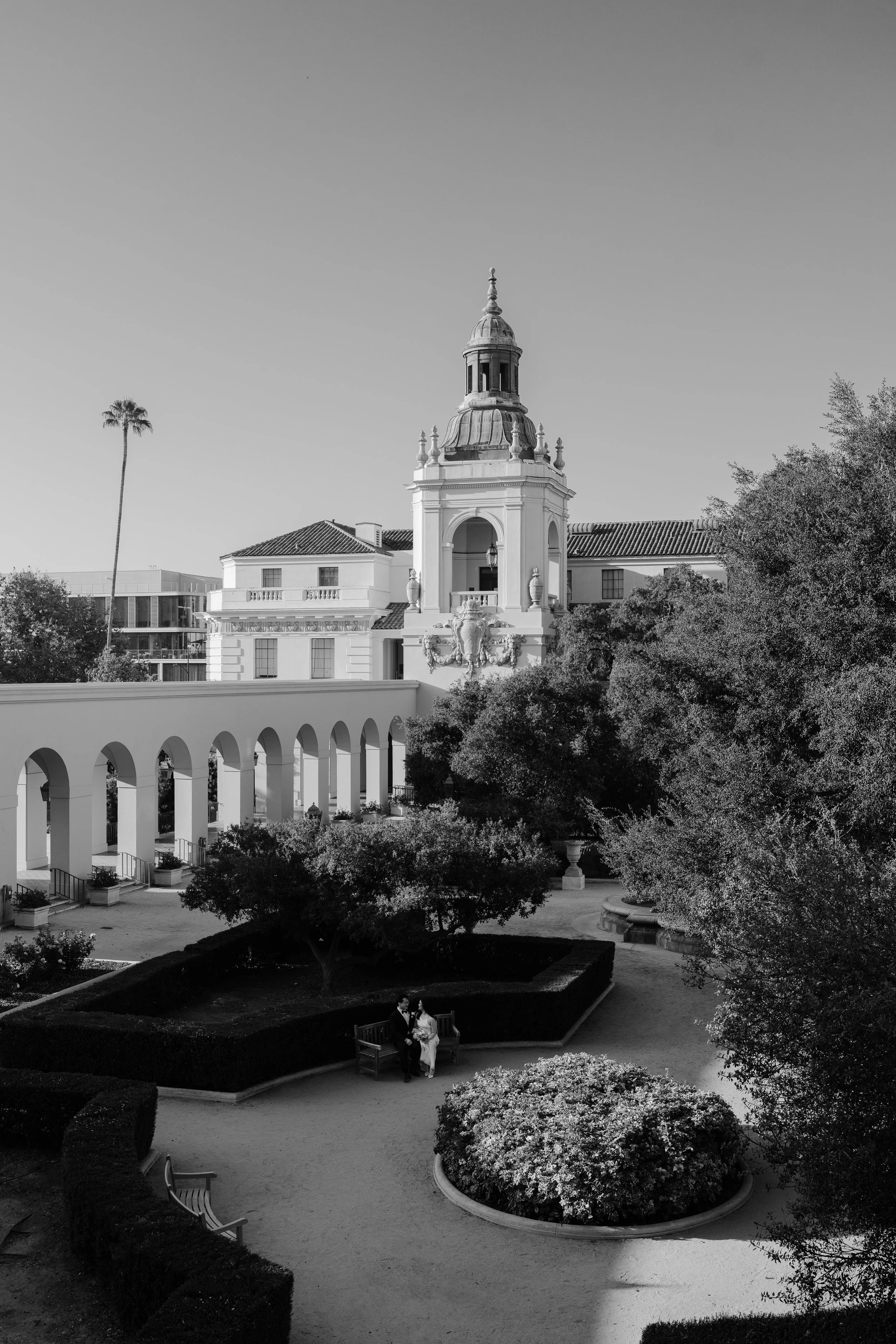Bride and groom sitting in the courtyard at Pasadena City Hall after their Cakewalk elopement ceremony.