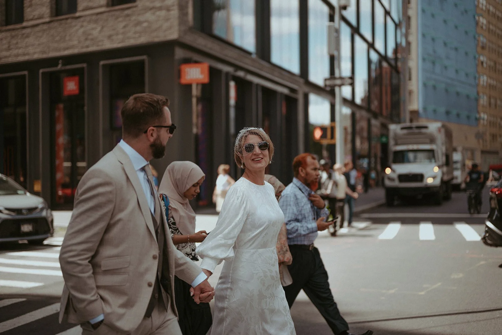 Bride and groom walking through SoHo streets among other commuters after their Cakewalk elopement. 