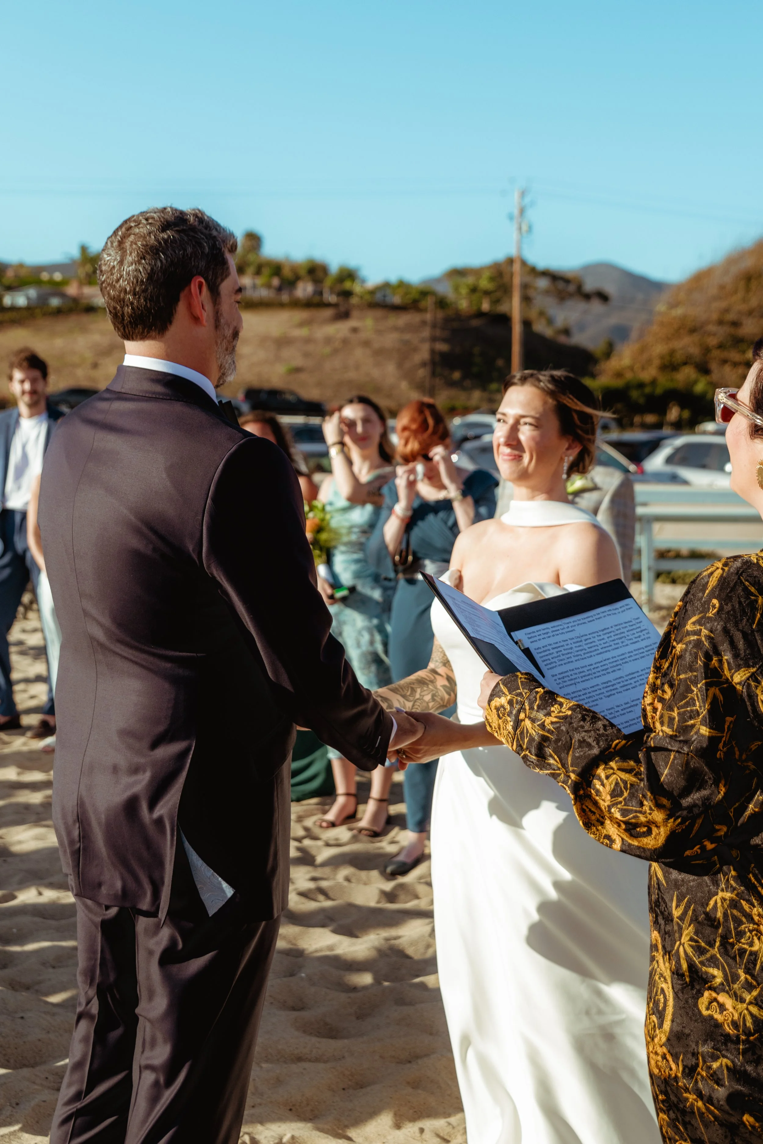 Bride, groom and officiant at the marriage ceremony on Zuma Beach in Malibu.