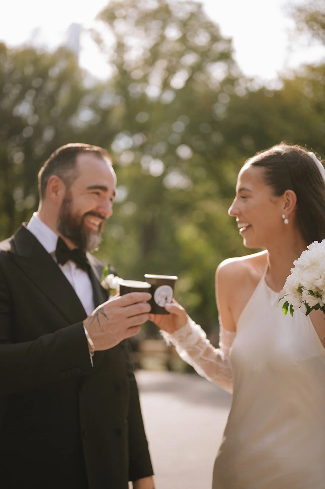 Bride and groom sharing coffees after their Cakewalk elopement at Naumburg Bandshell.