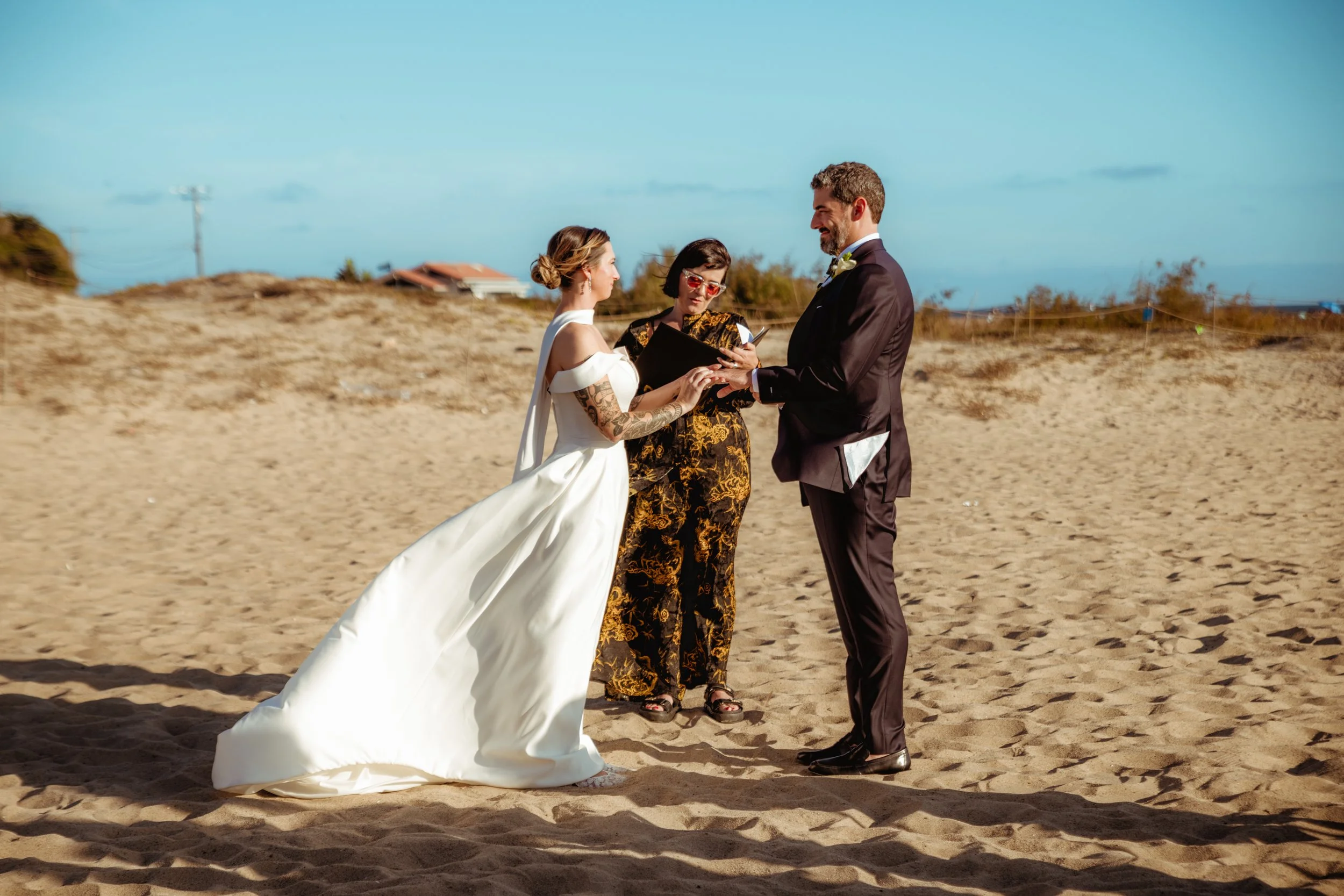 Bride, groom and officiant at the marriage ceremony on Zuma Beach in Malibu.