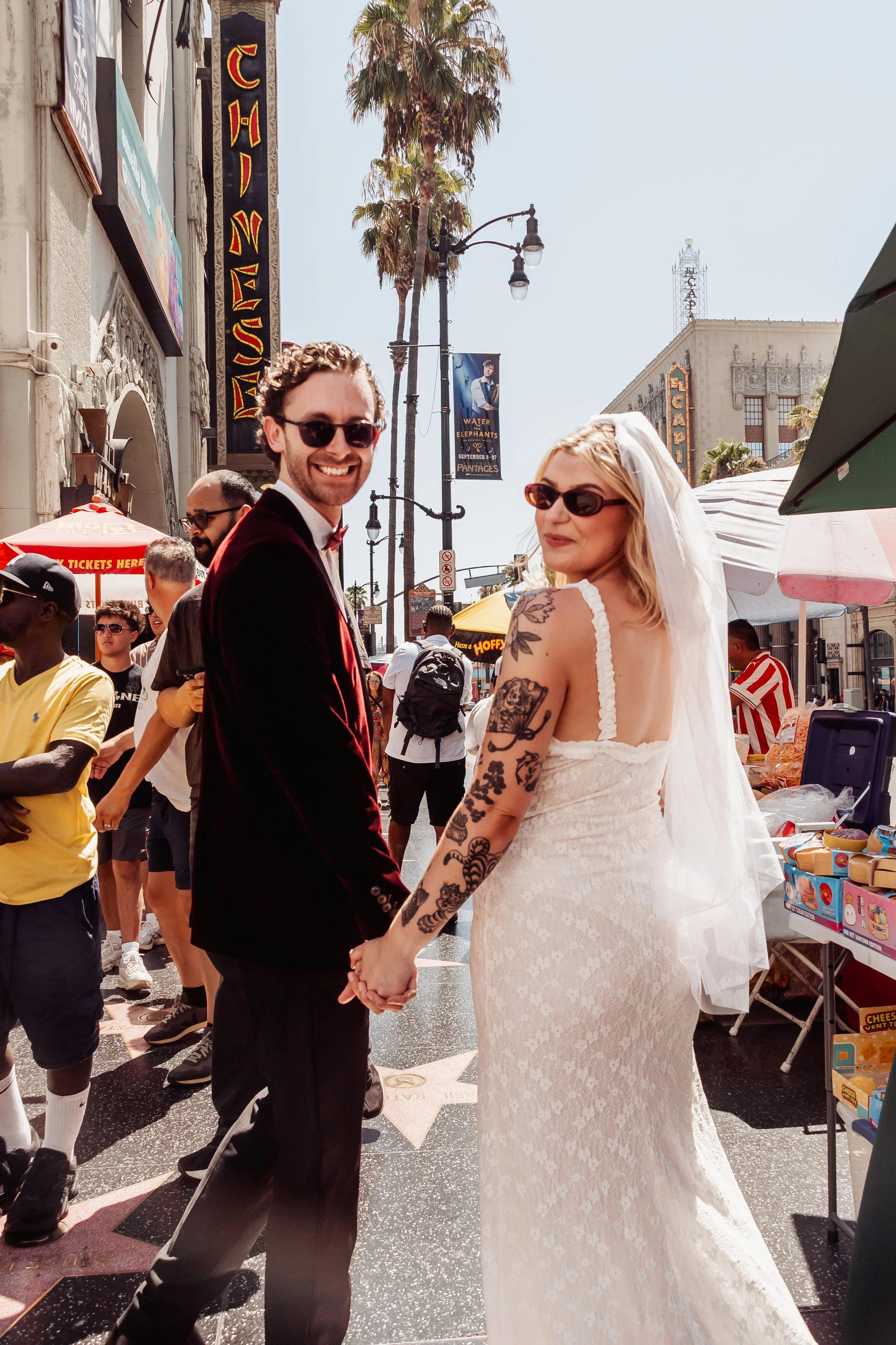 Couple walking down Hollywood Blvd in front of TCL Chinese Theatre during their Cakewalk elopement.