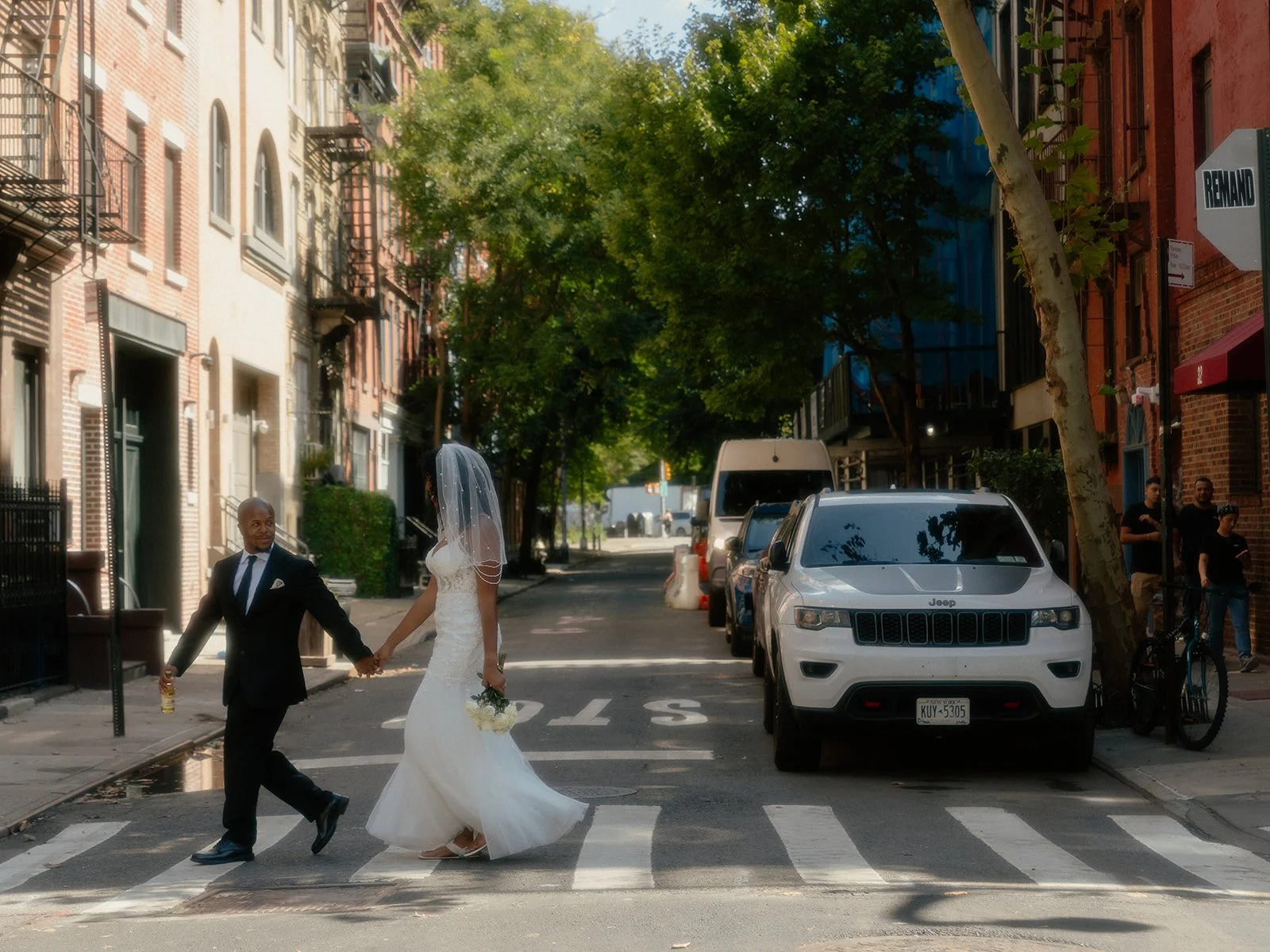 Bride and groom walking across the crosswalk in New York City after their Cakewalk wedding ceremony.