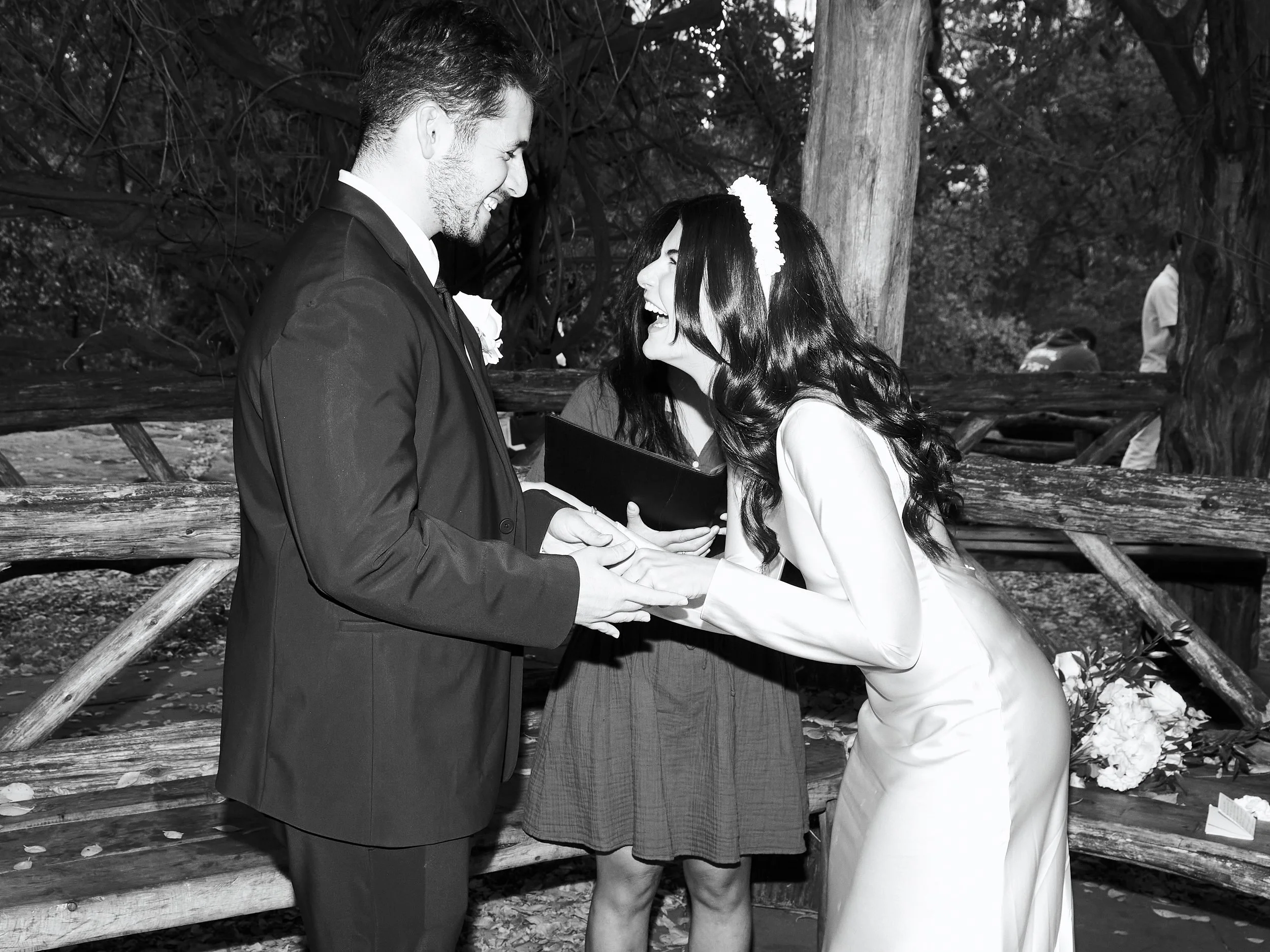 Black and white photo of Sharifa and Jafar holding hands during their Cop Cot ceremony in Central Park.
