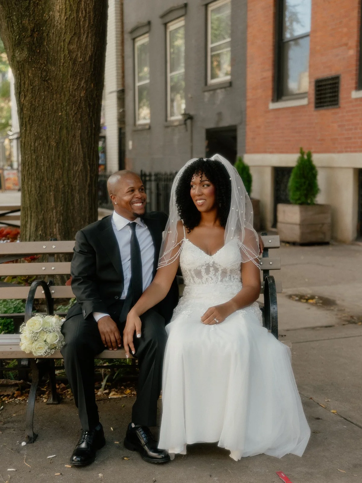 Bride and groom seated on a bench in New York City after their Cakewalk wedding ceremony.