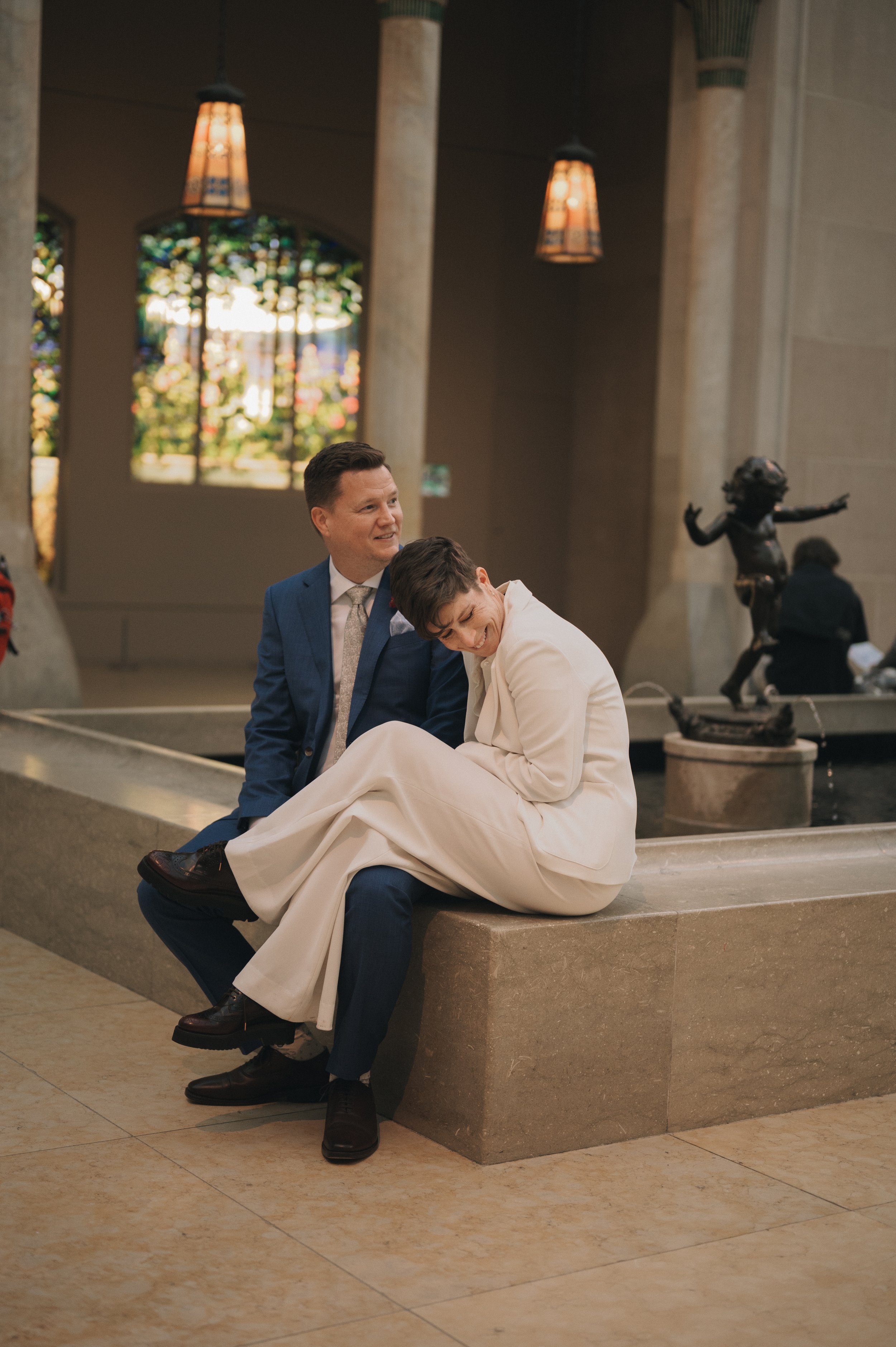 Couple laughing together near the fountain in The Met’s American Wing courtyard.