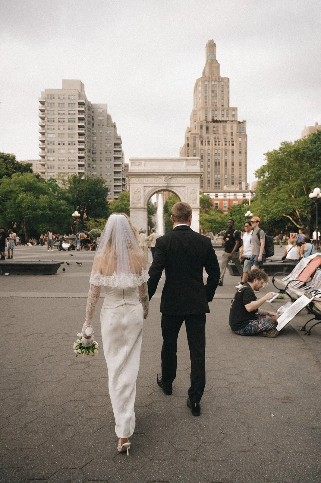 Couple walking through Washington Square Park with the arch in the background after their Cakewalk ceremony.