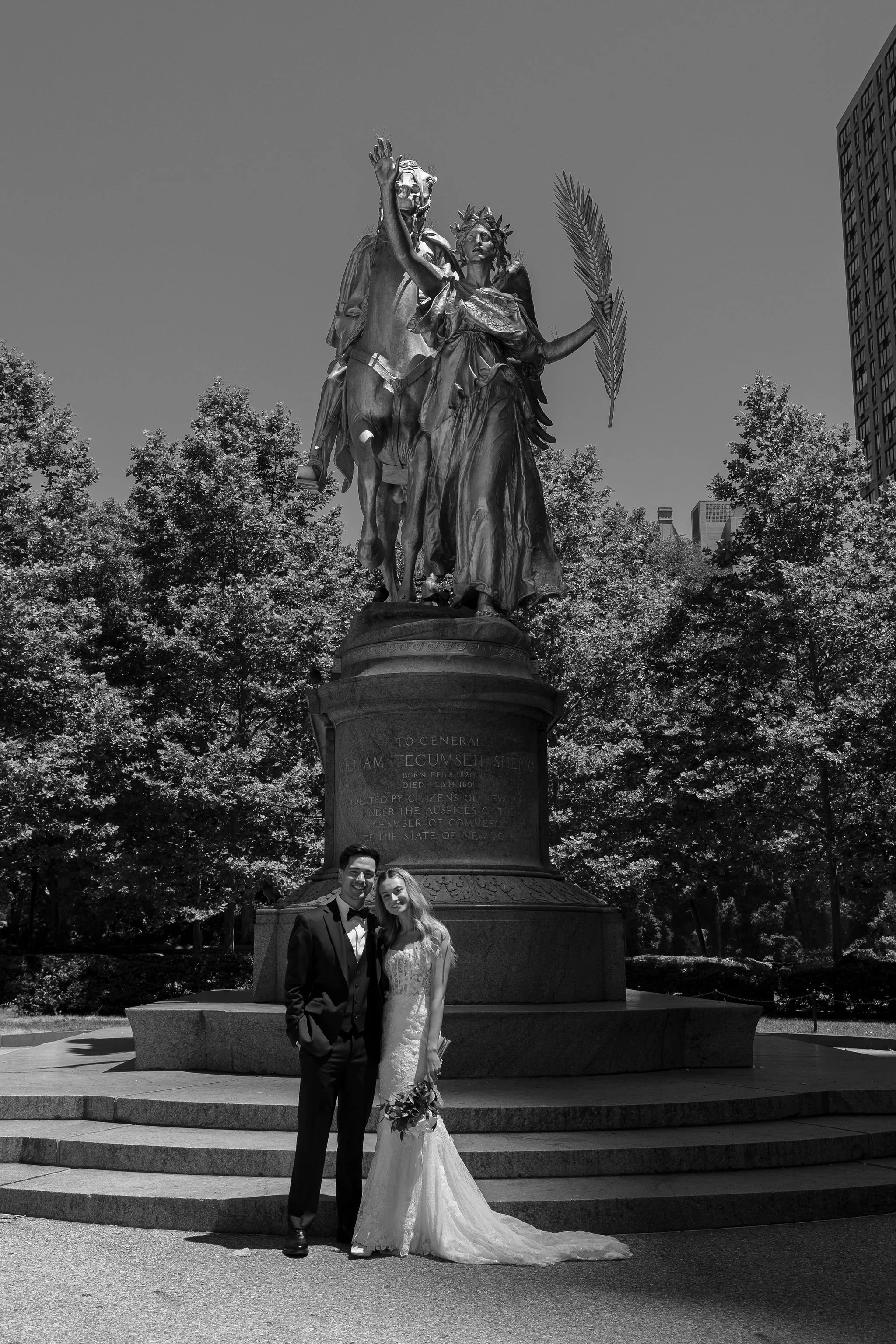 Bride and groom posing in front of the  General William Tecumseh Sherman Monument at the southeastern entrance of Central Park in Grand Army Plaza before their Cakewalk elopement.