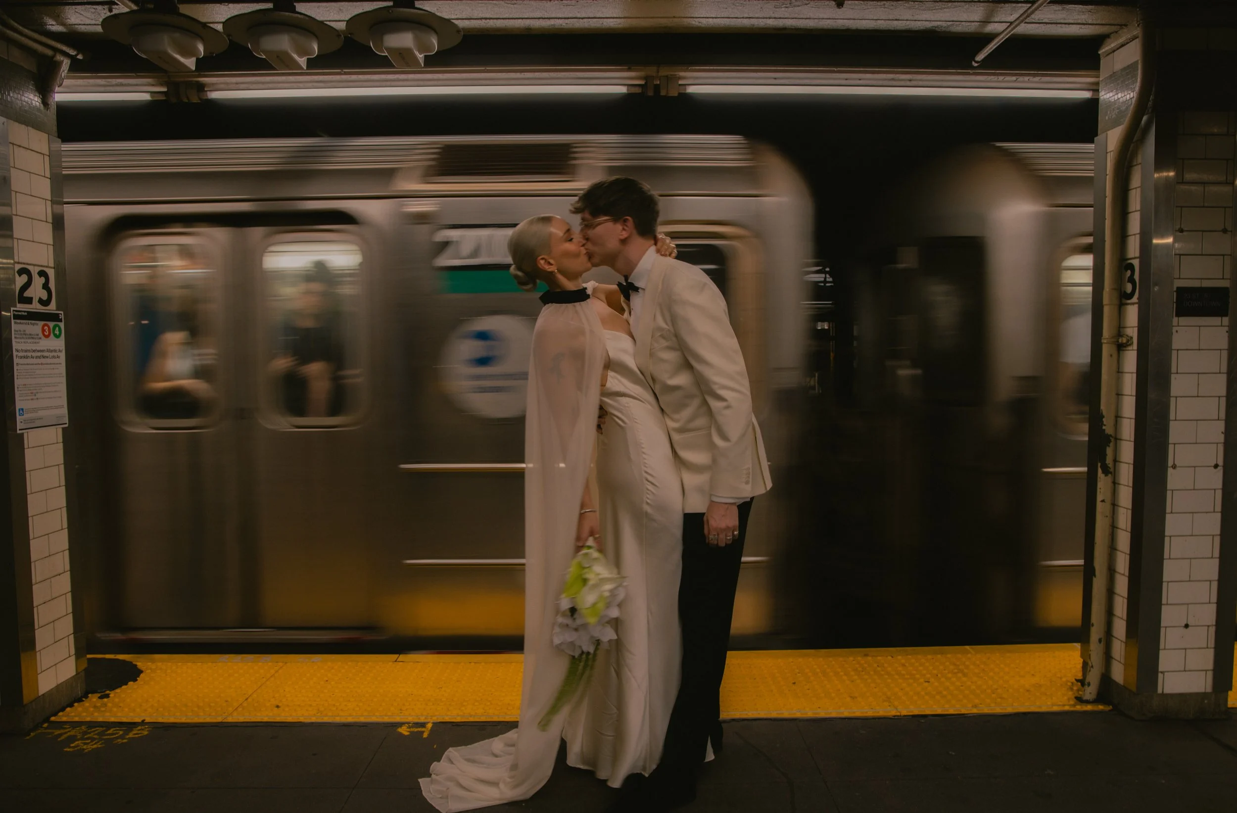 Couple kisses in front of the subway in a documentary style wedding photo after their elopement at Bethesda Terrace.