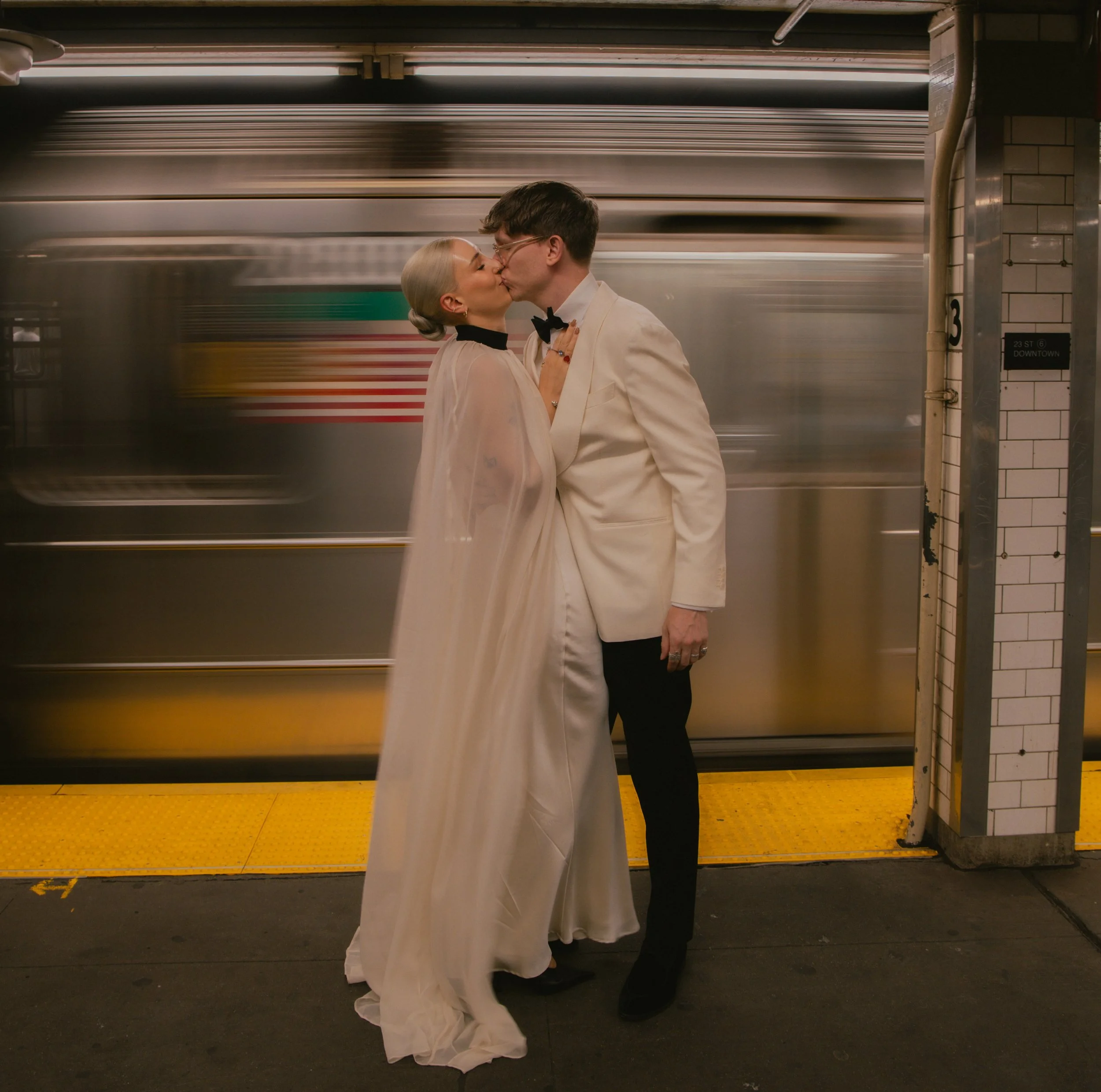 Bride and groom kissing in front of a New York City subway train in motion after their Cakewalk elopement.