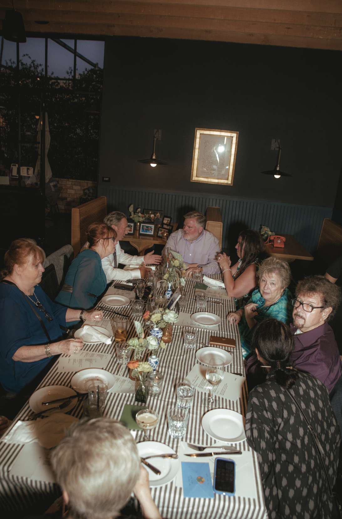 Family of the bride and groom seated at a large table at their intimate reception after their Cakewalk micro wedding.