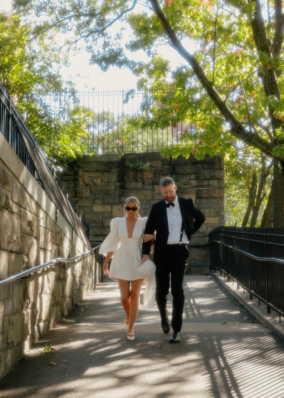 Bride and groom walking down an incline toward the DUMBO area of Brooklyn after their Cakewalk wedding ceremony.