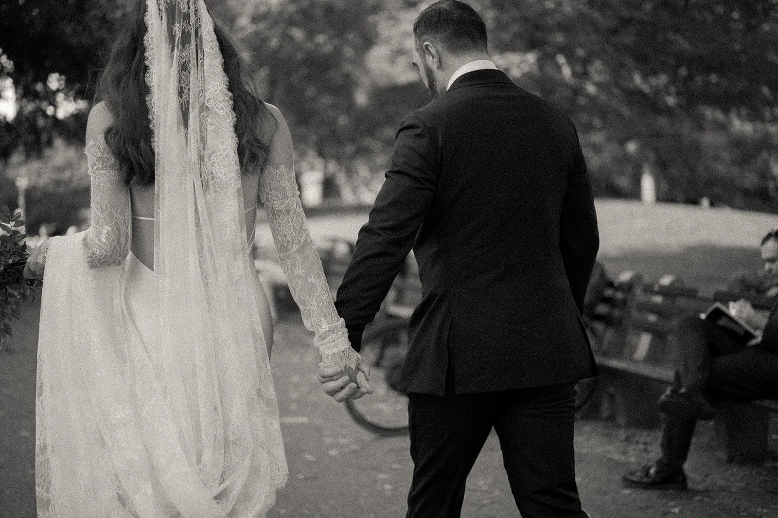 Bride and groom walking to their wedding ceremony in Central Park, holding hands.