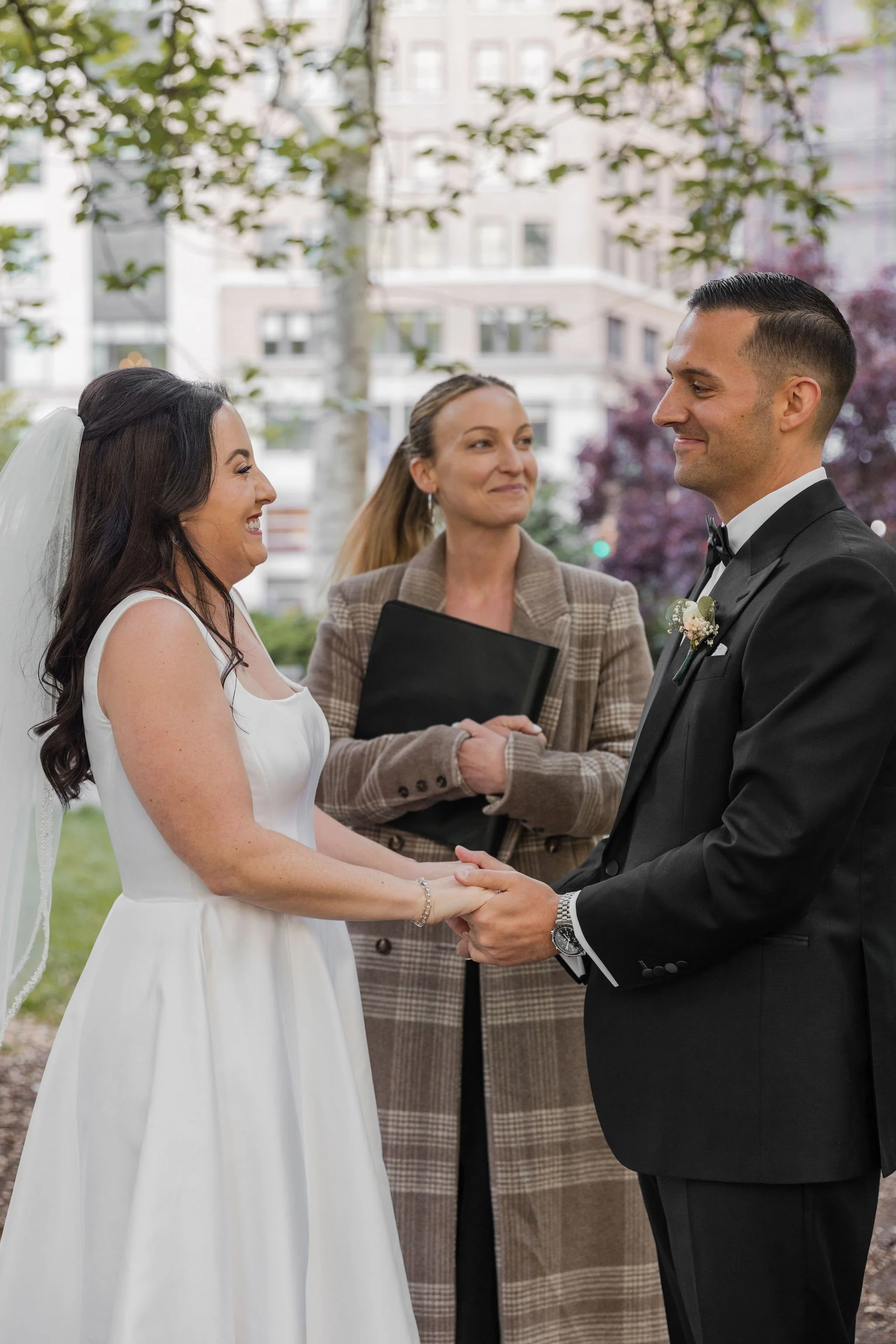 A couple looks into each other's eyes at Madison Square Park just before their elopement ceremony is going to be officiated by Cakewalk.