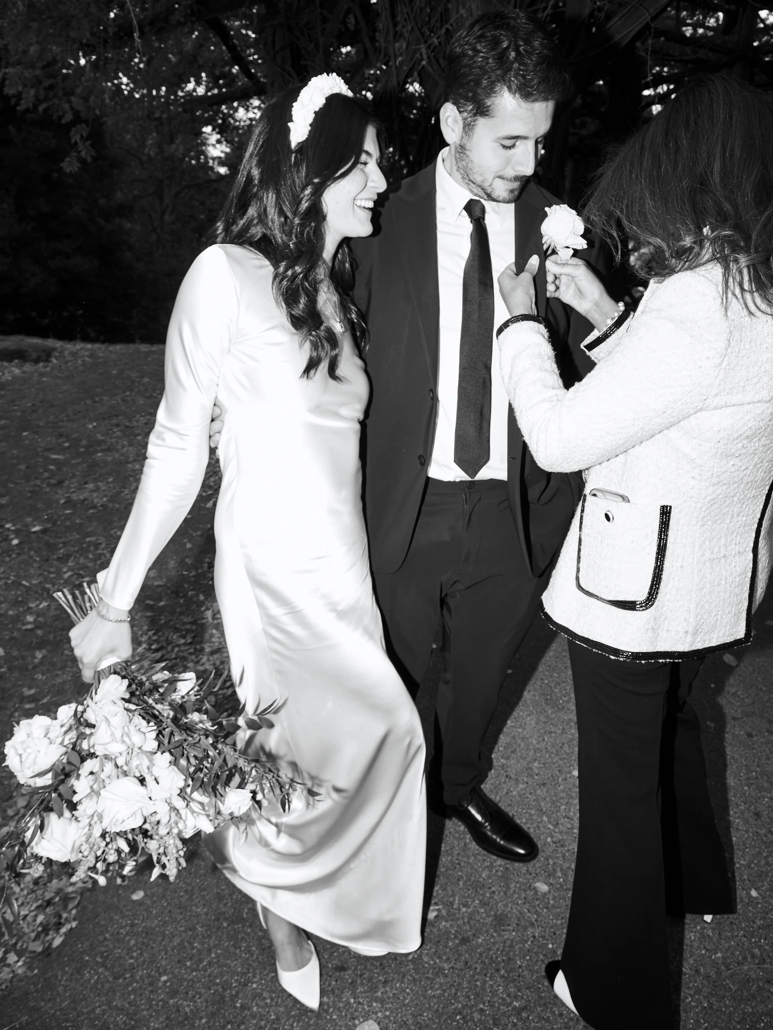 Bride and groom arriving at their Cop Cot wedding ceremony and a family member attaching the flowers to the groom's jacket.