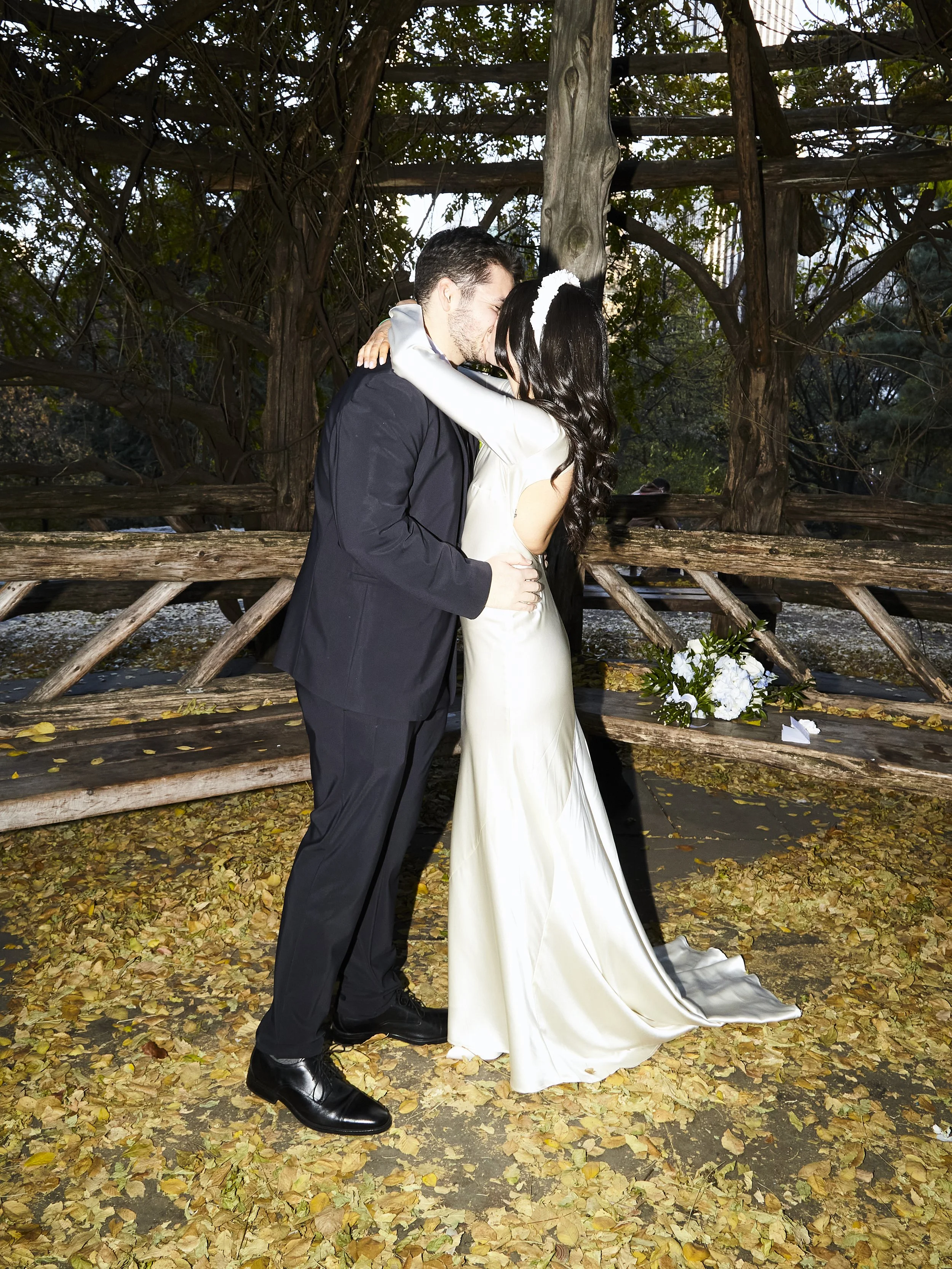 Sharifa and Jafar kissing under Cop Cot during their fall Central Park wedding ceremony with Cakewalk.