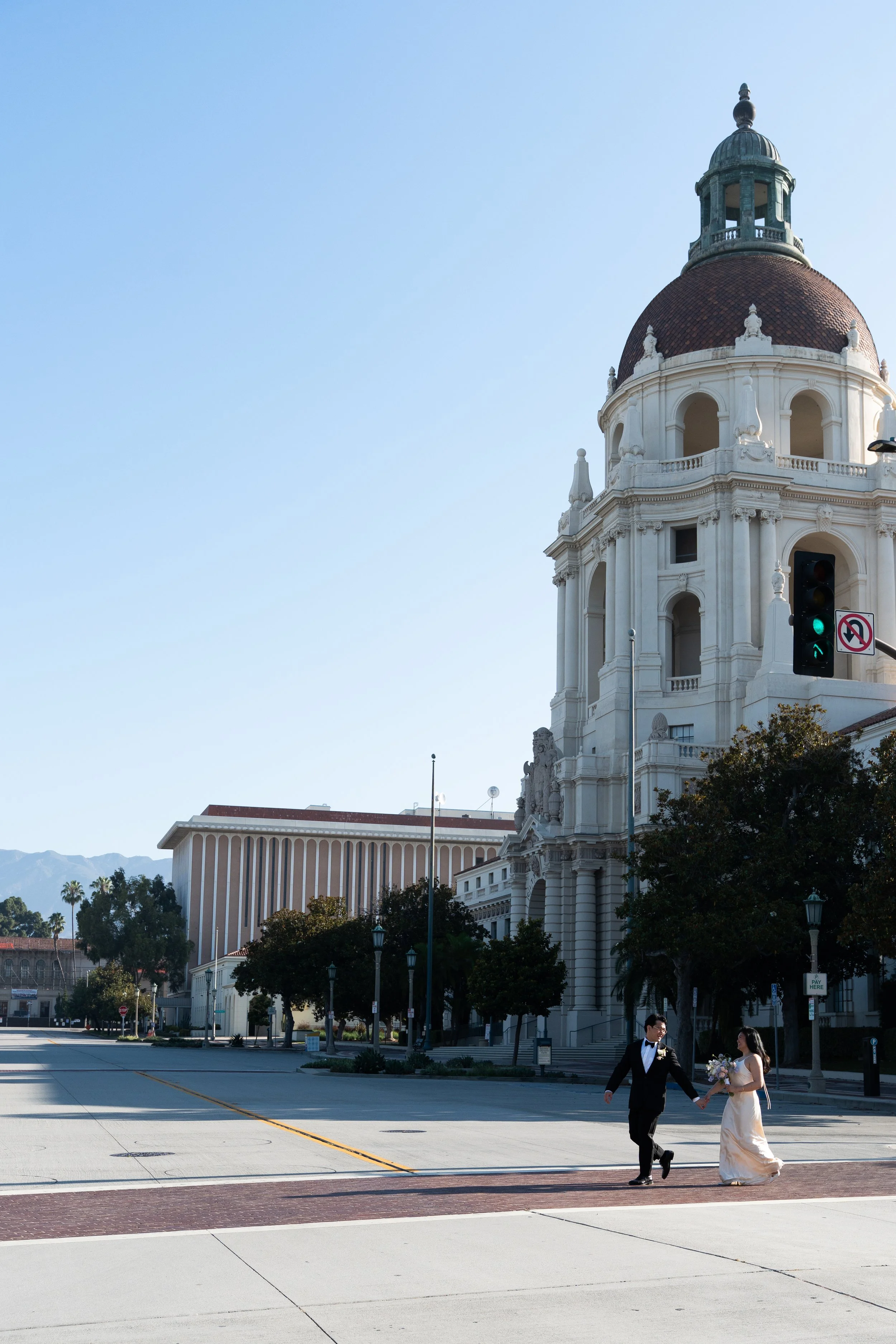 Bride and groom crossing in front of Pasadena City Hall after their Cakewalk elopement.