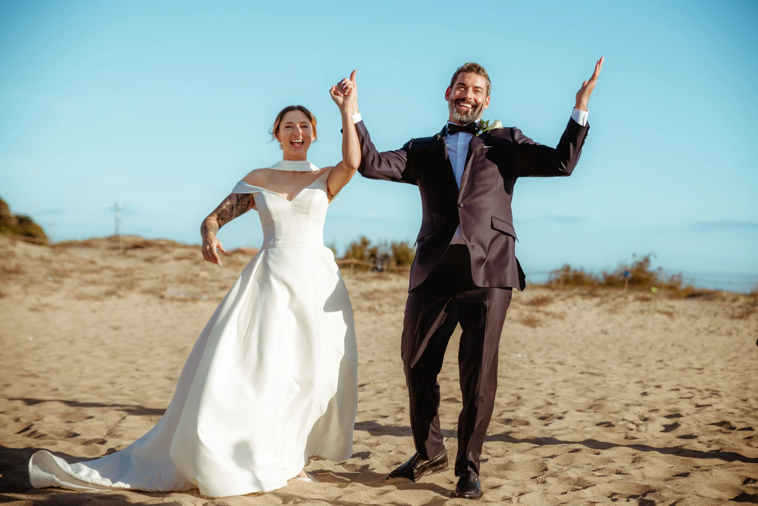 Bride and groom celebrating on the sand at Zuma Beach after their Cakewalk micro wedding.