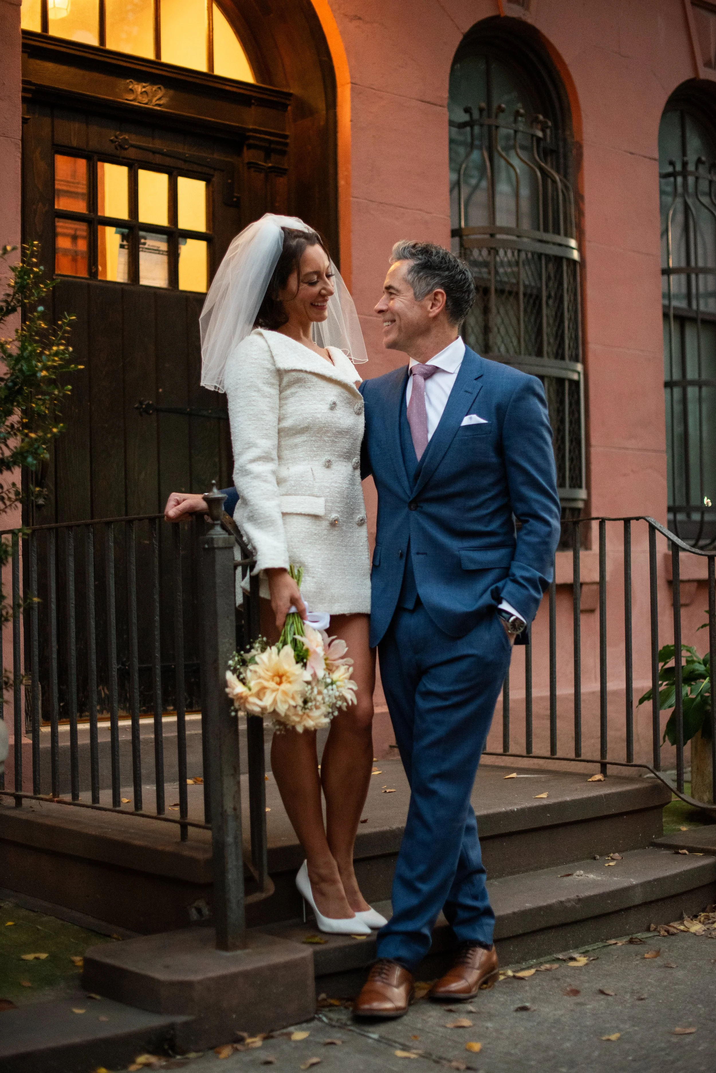 Bride and groom posing in a doorway in the West Village after their Cakewalk elopement ceremony.