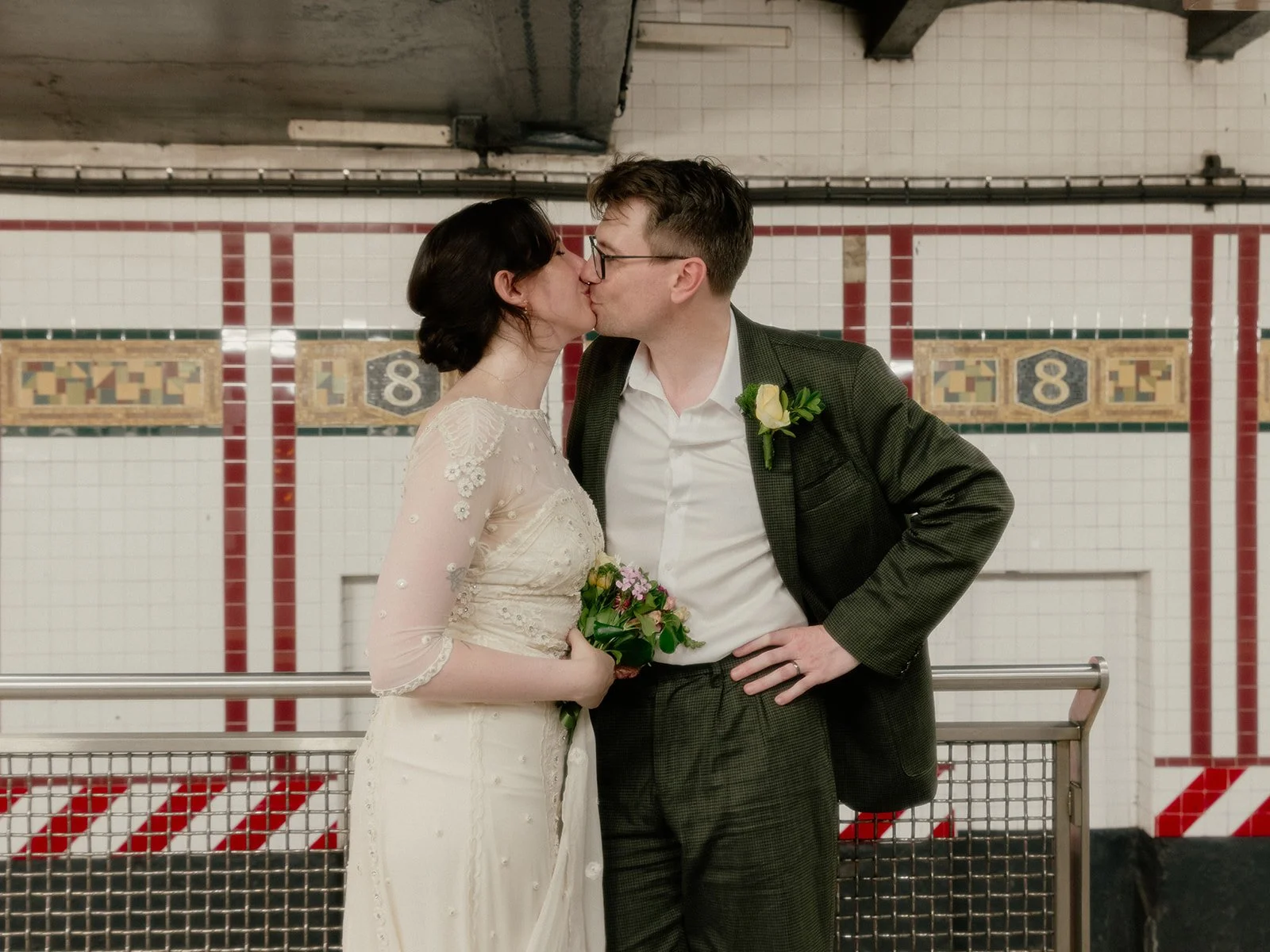 Bride and groom kissing in the subway station, waiting for the train in New York City. 