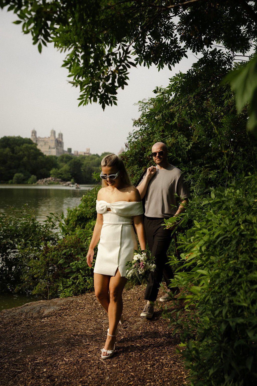 Chloe on the wooden dock at Wagner Cove in Central Park during her Cakewalk NYC elopement, holding her bouquet.