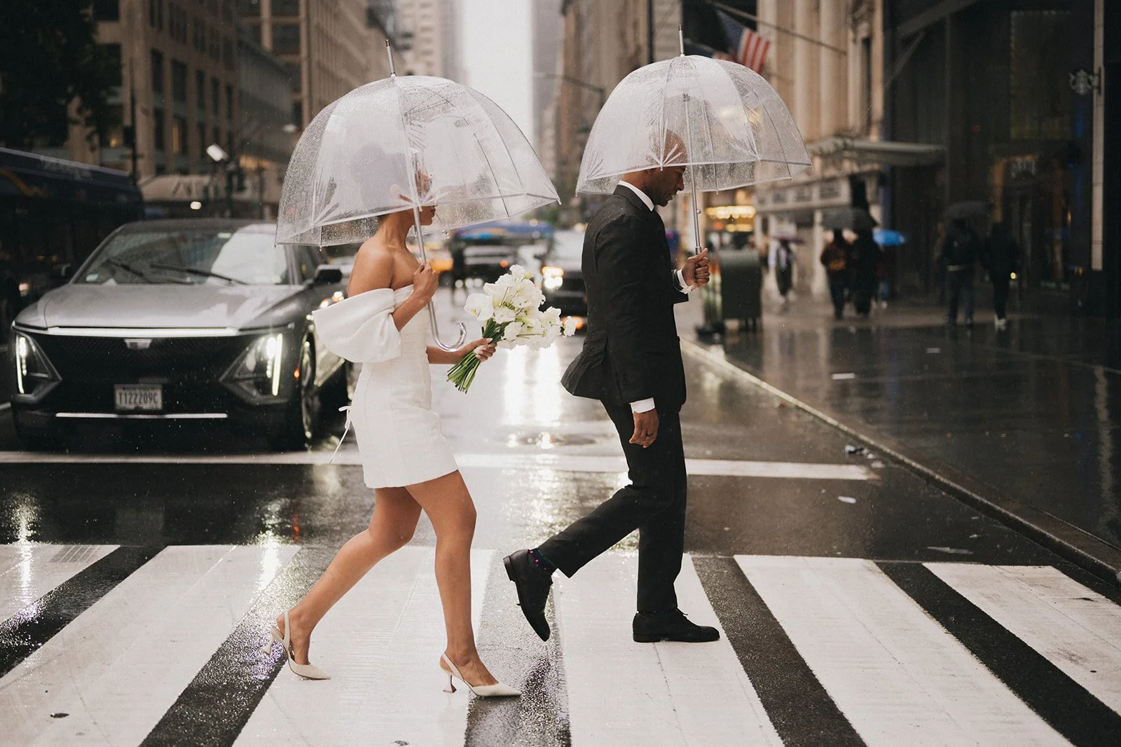 A couple crossing the New York City streets in the rain at their Cakewalk elopement.