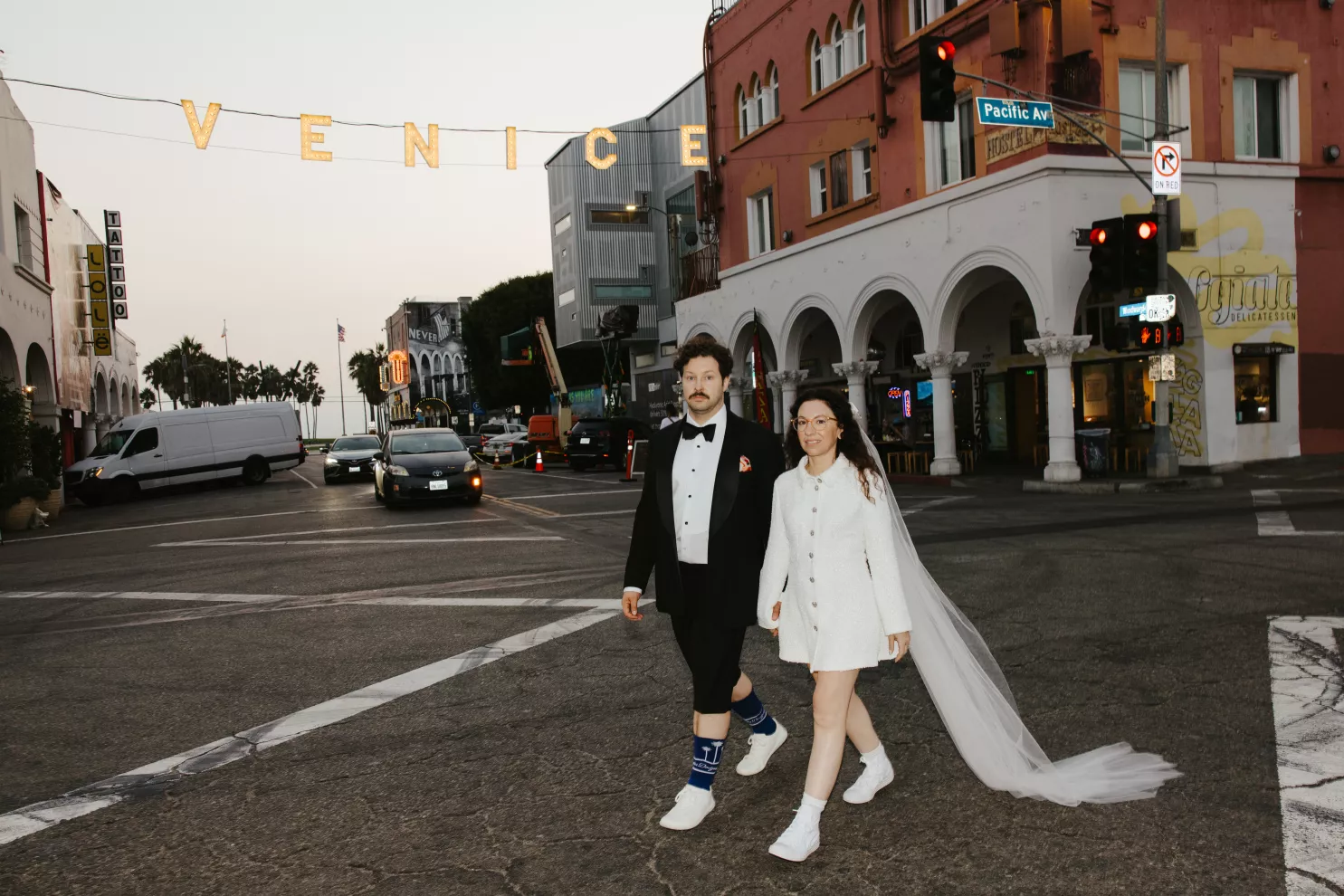 Newlyweds crossing under the Venice sign, a Los Angeles elopement
