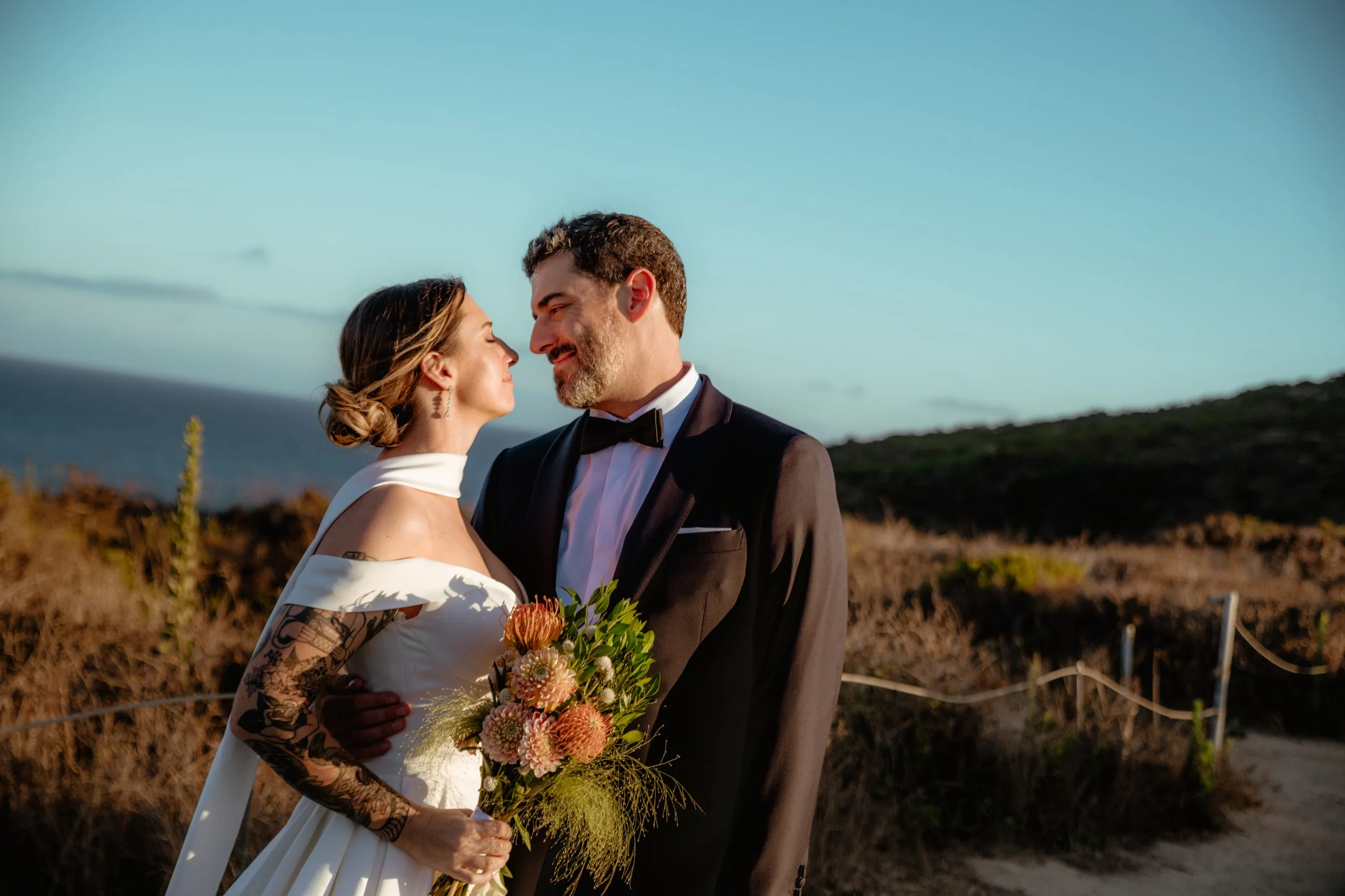 Bride and groom looking at each other with the ocean in the background at Point Dume after their Cakewalk micro wedding.