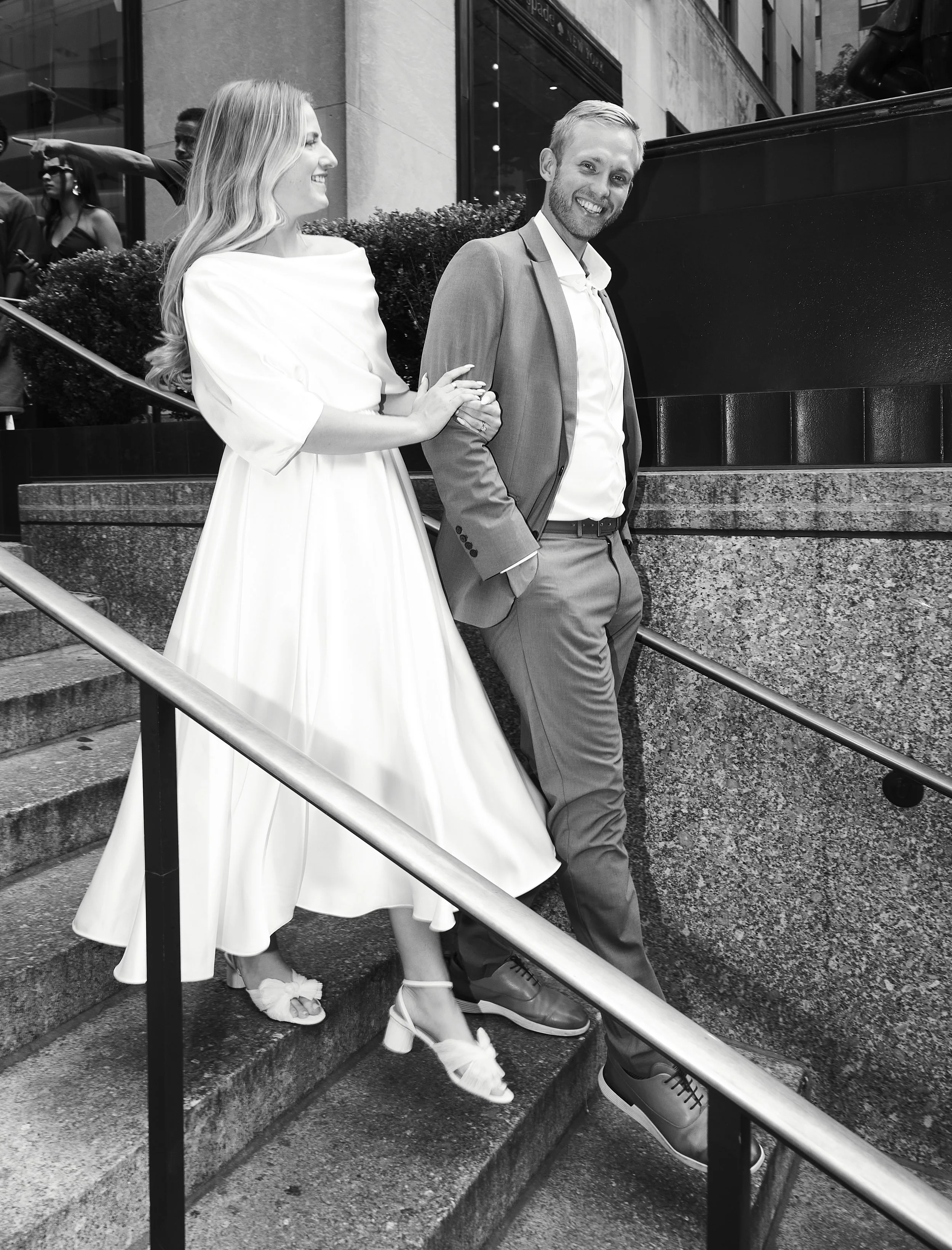 Bride and groom walking down the stairs at Rockefeller Center after their Cakewalk elopement.